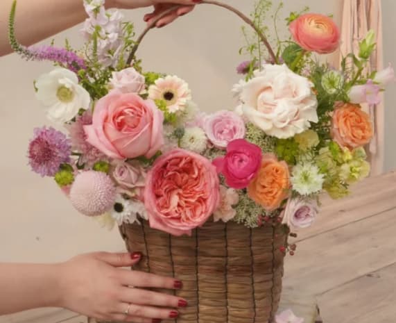 Adeline Basket - Inspired by bright nature and soft textures, this arrangement will wow your loved ones with its mix of roses  and seasonal flowers and foliage in  a woven basket. The customer can choose between light, bright or mixed colors.