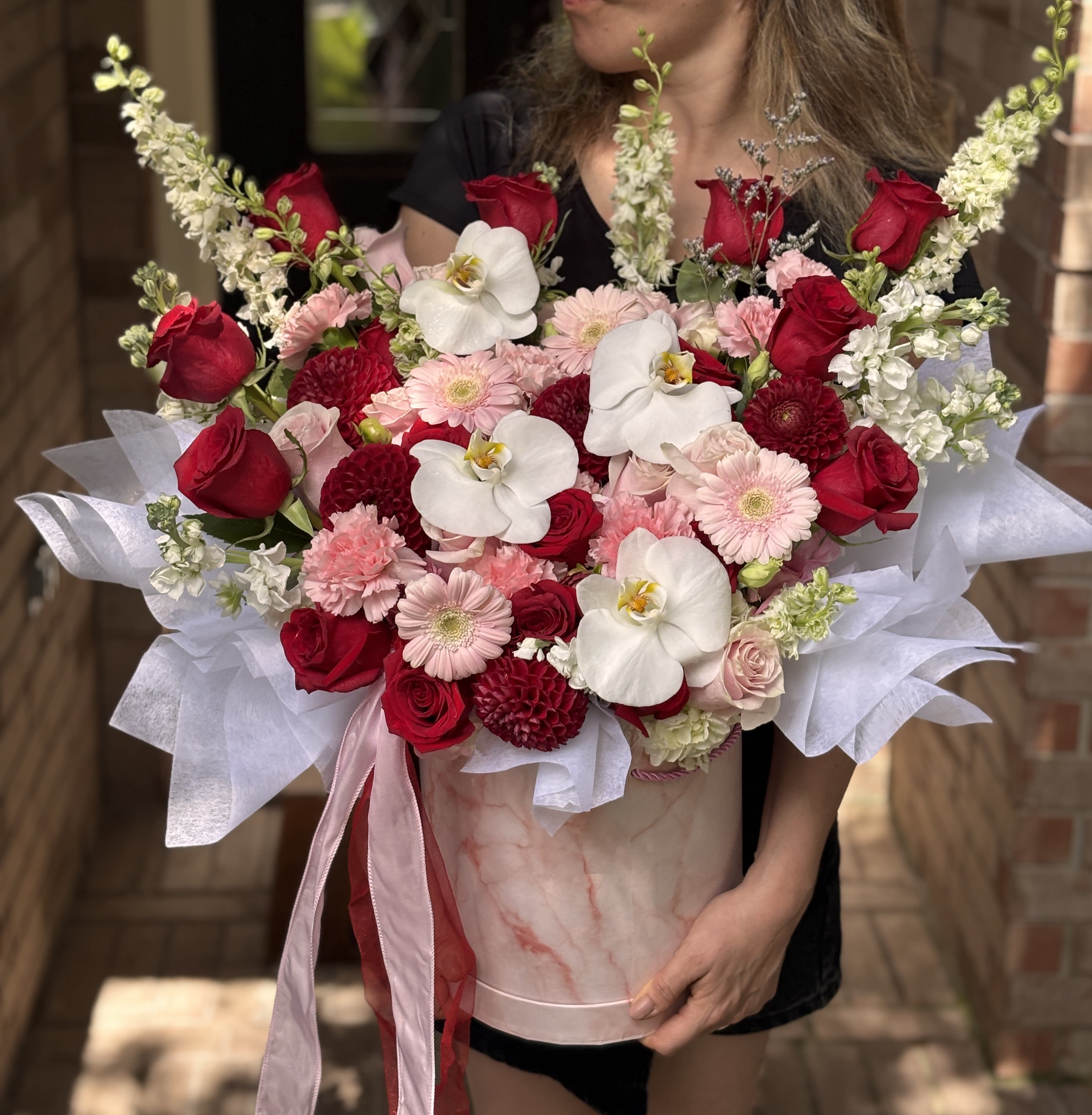 Antolina Box - Make someone's day extra special with the Antolina Floral Box! This vibrant, fragrant mix of freshly roses, orchids, and seasonal blooms is artfully arranged in a chic floral  box, creating a stunning and elegant gift sure to brighten any room.