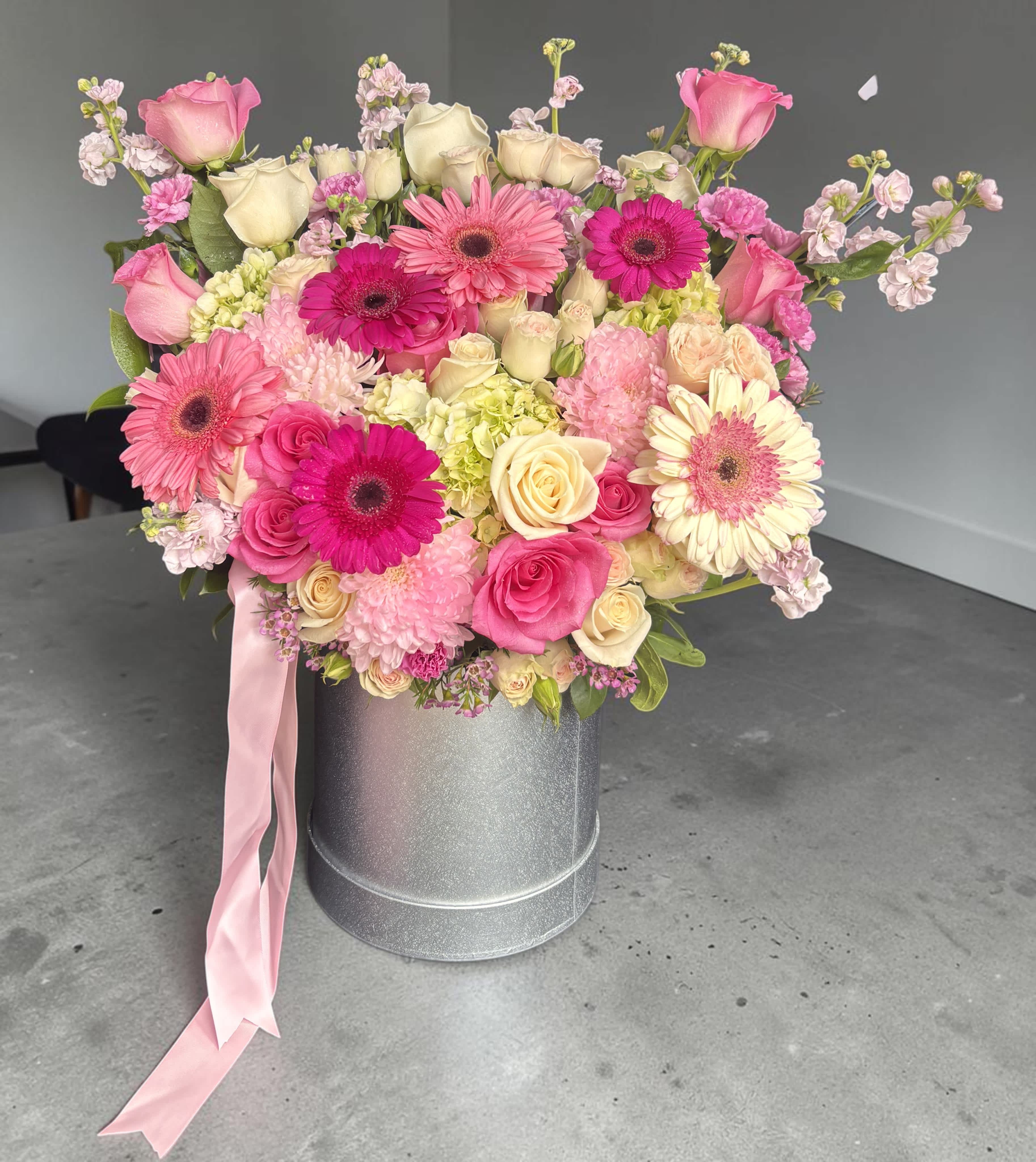Pink and cream mixed bouquet in a silver hatbox with a pink ribbon