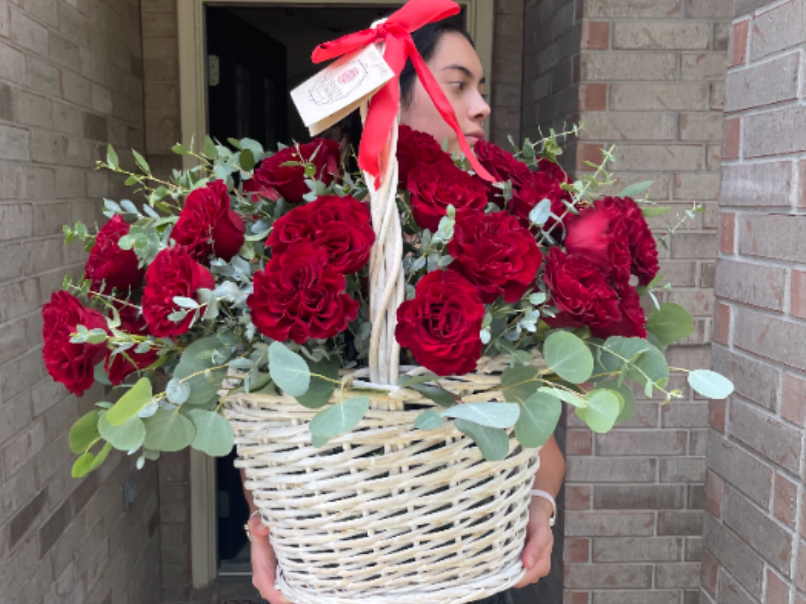 Basket of red roses with eucalyptus and a red ribbon
