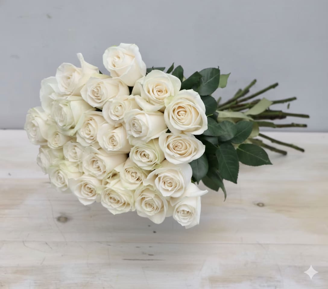 Hand-tied bouquet of long-stemmed ivory roses resting on a light wooden surface