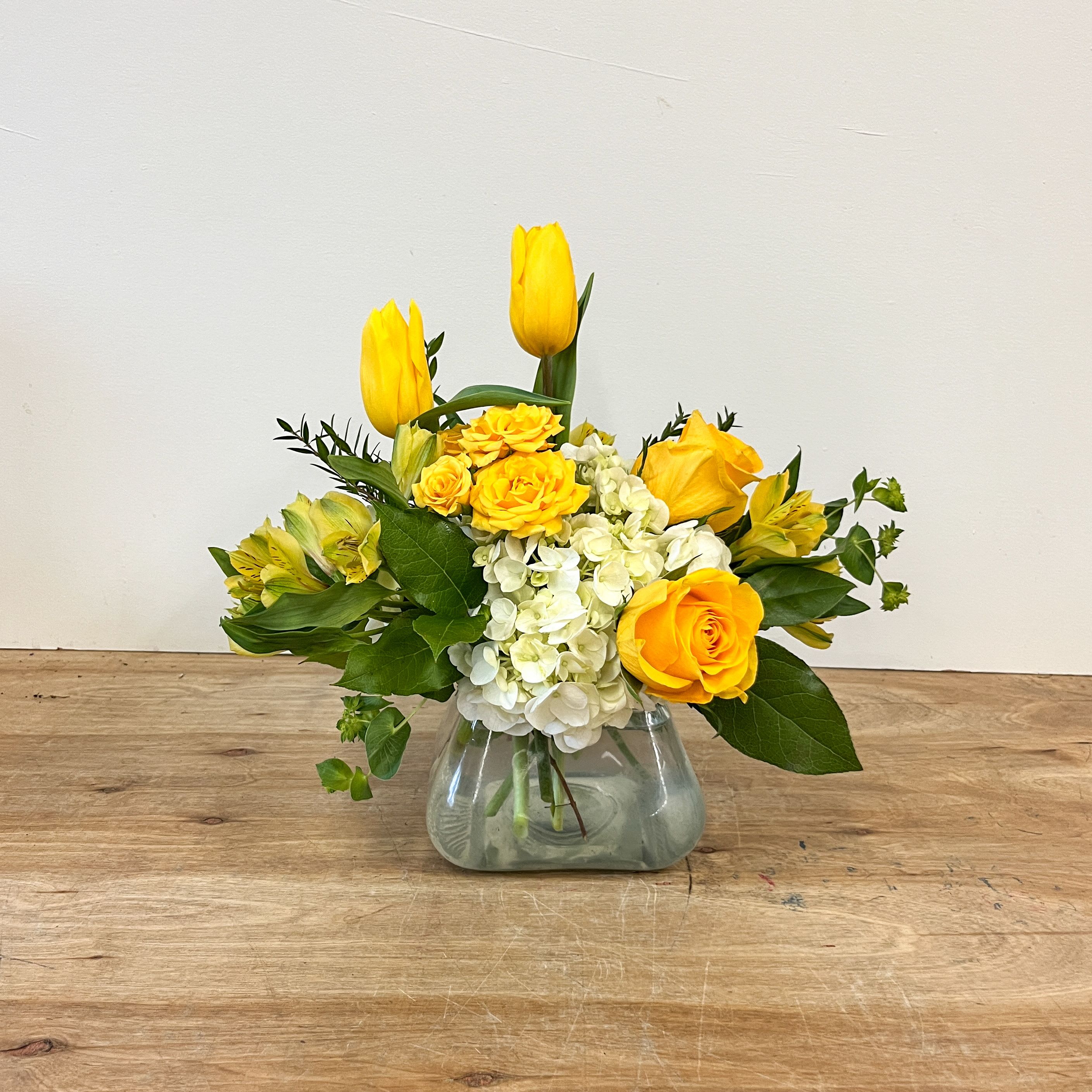 Sunny days ahead - There's a beautiful simplicity in the color palette of yellows and whites. Your Mom is sure to want to go outside and enjoy her day after receiving this beauty! This bouquet is the perfect size for an outdoor table centerpiece or a side table.