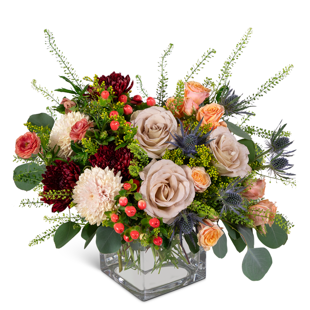 Mixed bouquet of roses, chrysanthemums, and berries in a clear square vase