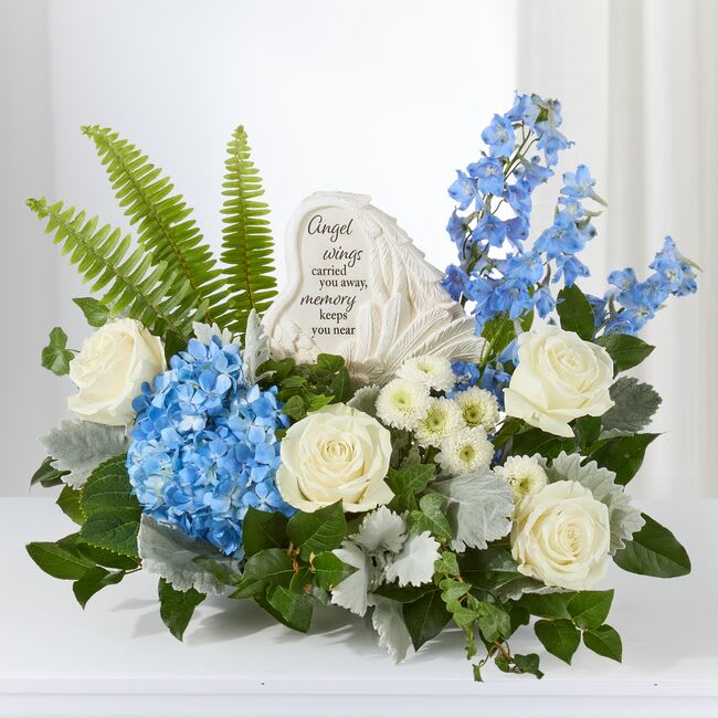 Blue and white floral sympathy arrangement with a memorial stone