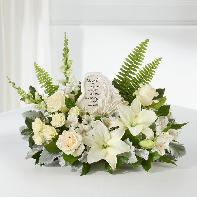 White floral sympathy arrangement with an angel memorial plaque