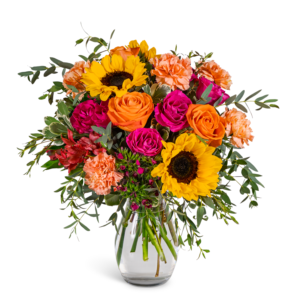 Bouquet of sunflowers, roses, and carnations in a clear glass vase