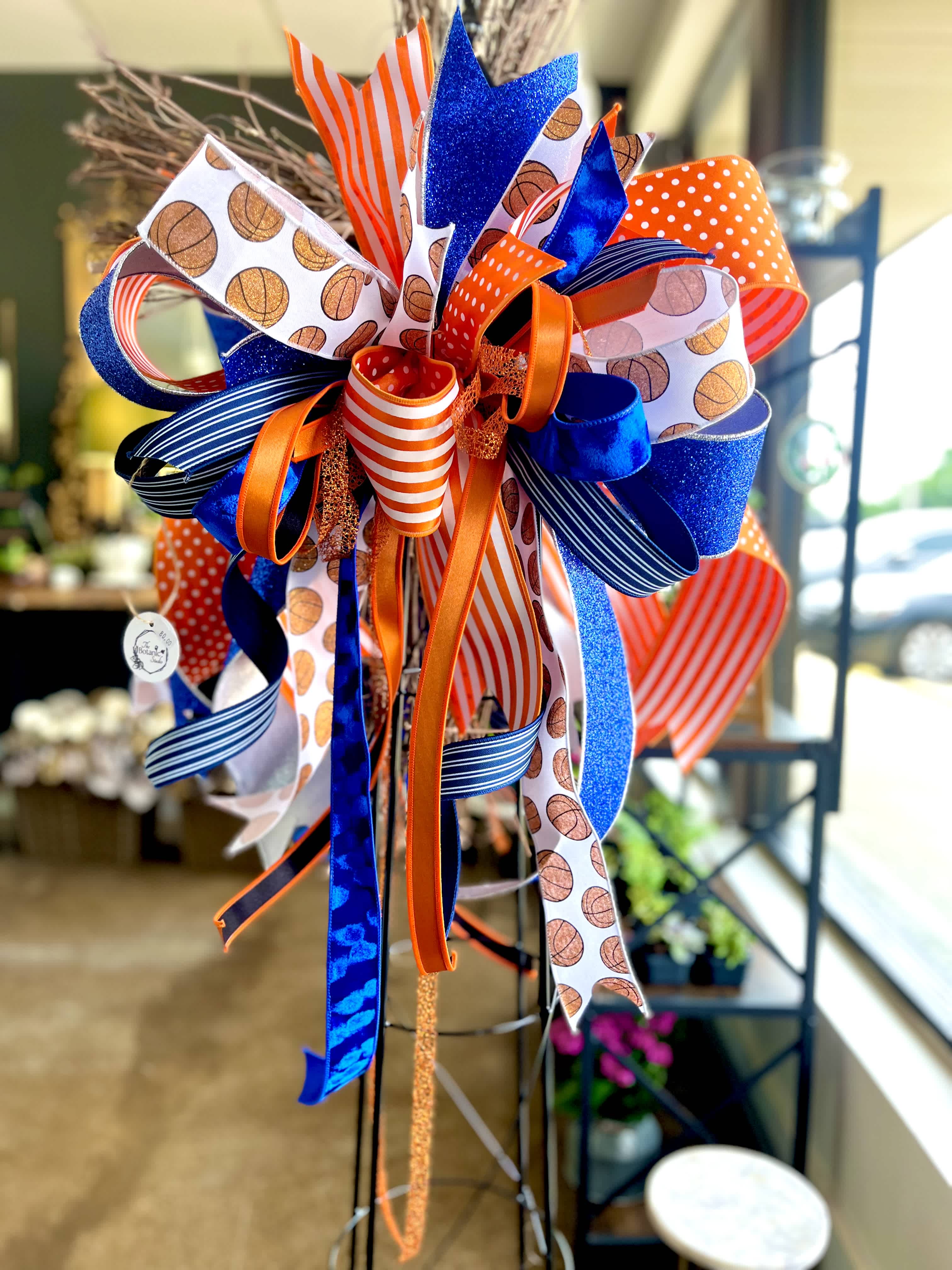 Decorative ribbon bow in blue, orange, and white with basketball patterns