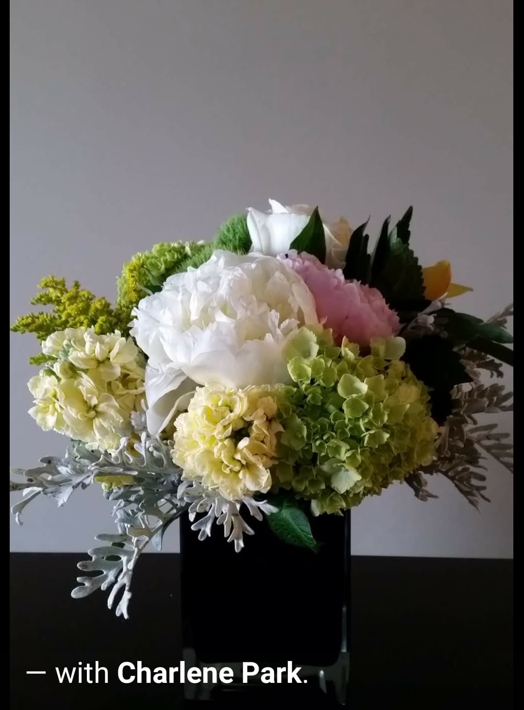 Bouquet of white, pink, and green flowers in a black vase