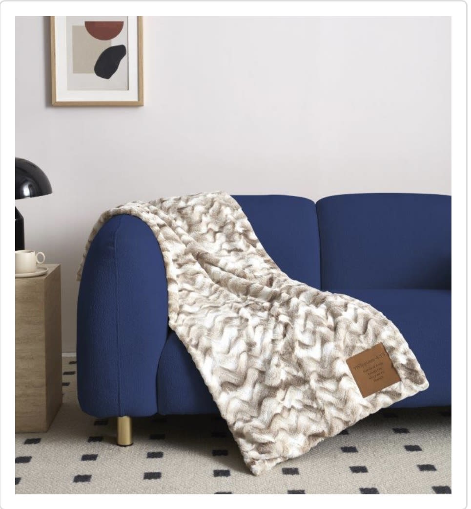 Patterned throw blanket draped over a blue sofa