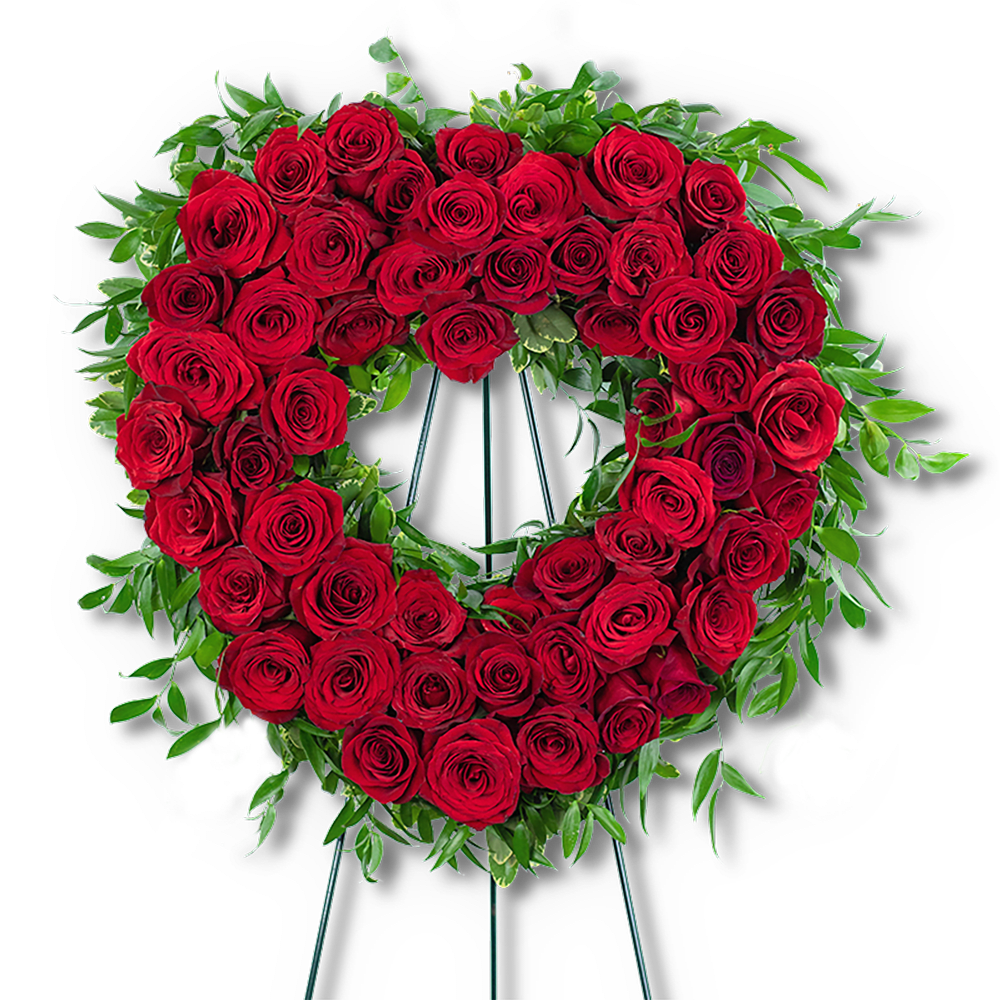 Heart-shaped wreath of red roses with green foliage on a stand