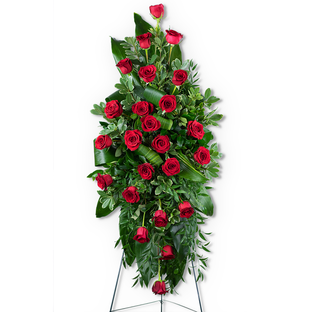 Tall standing spray of red roses with lush greenery on a black easel