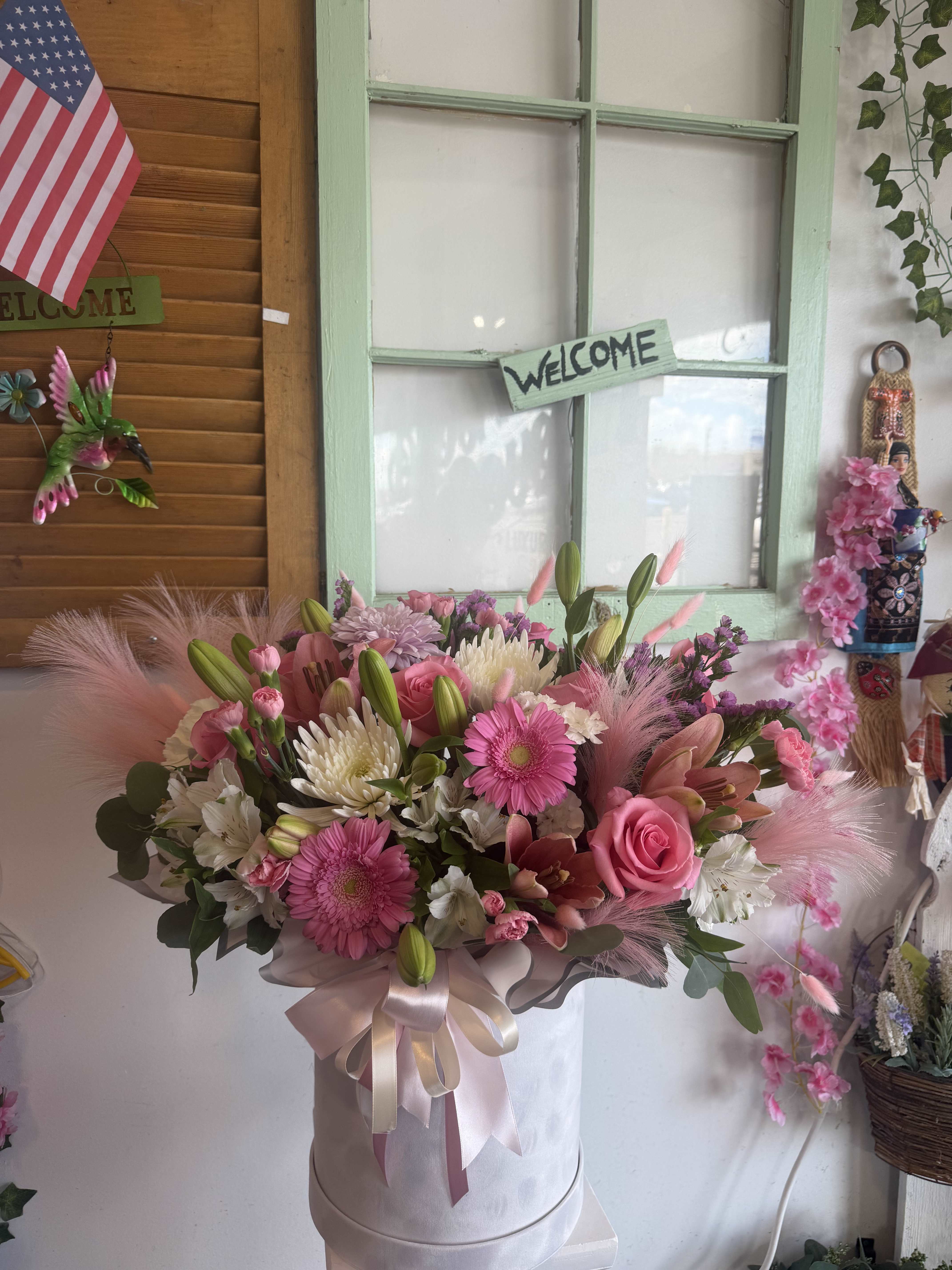 Pink and white mixed bouquet in a round hatbox with ribbon
