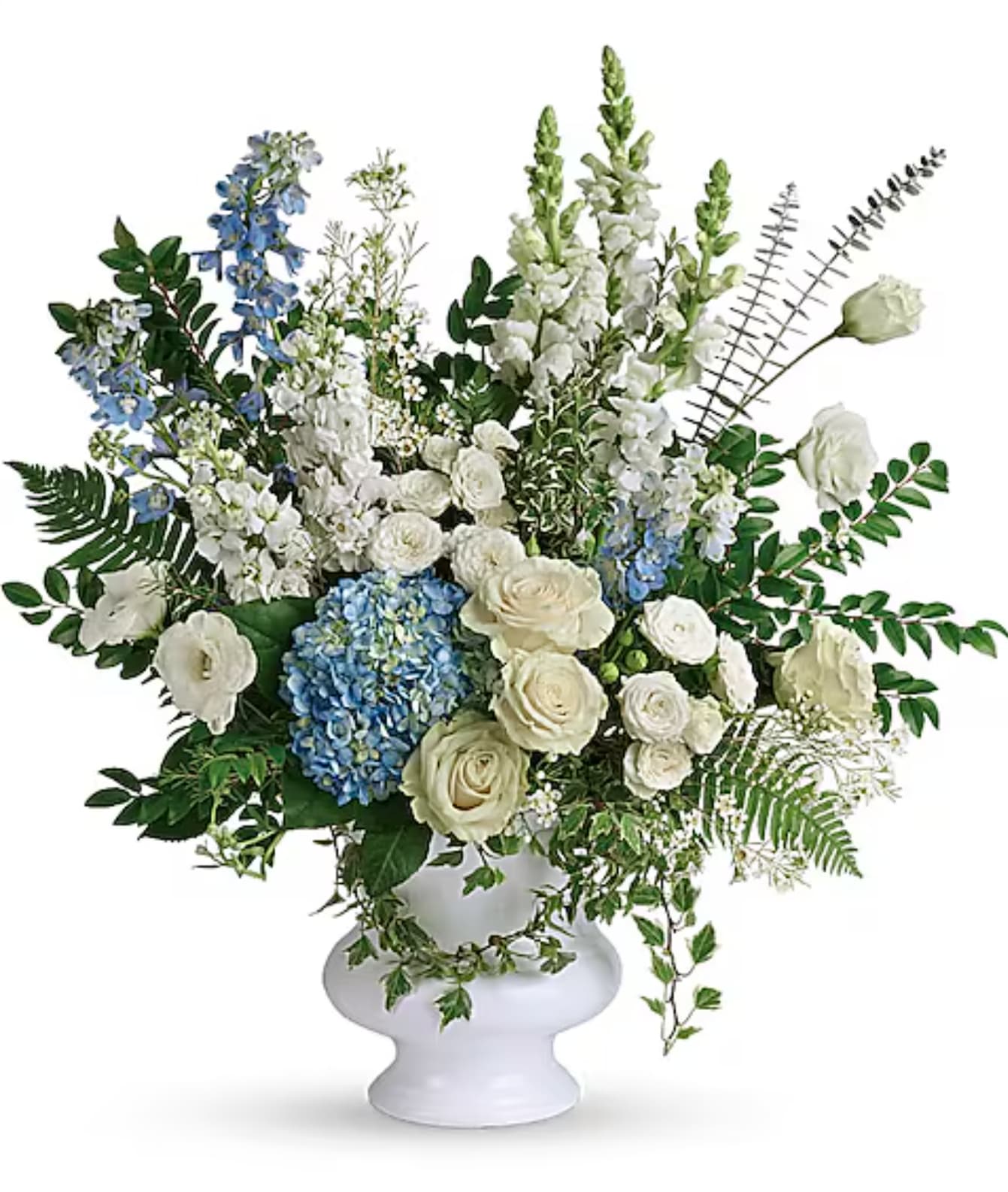 White and blue floral arrangement in a white pedestal vase