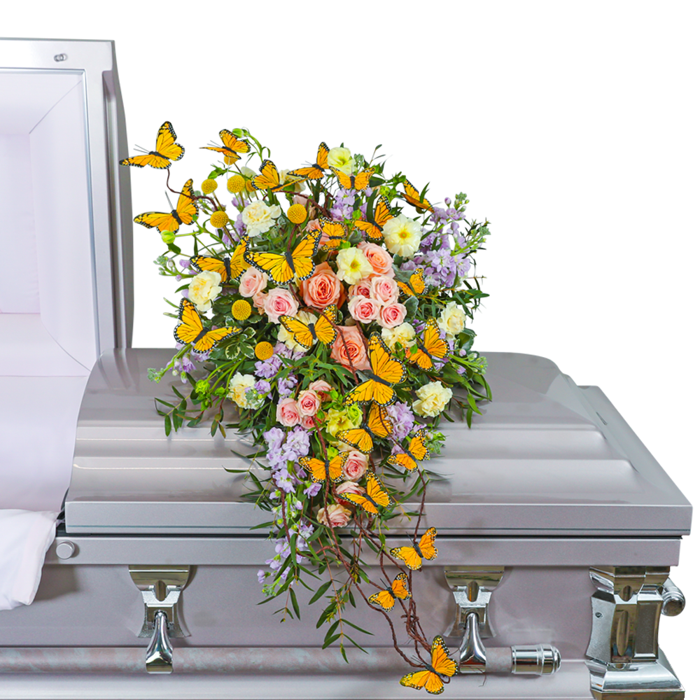 Casket spray with pink and cream roses, lavender flowers, and orange butterflies