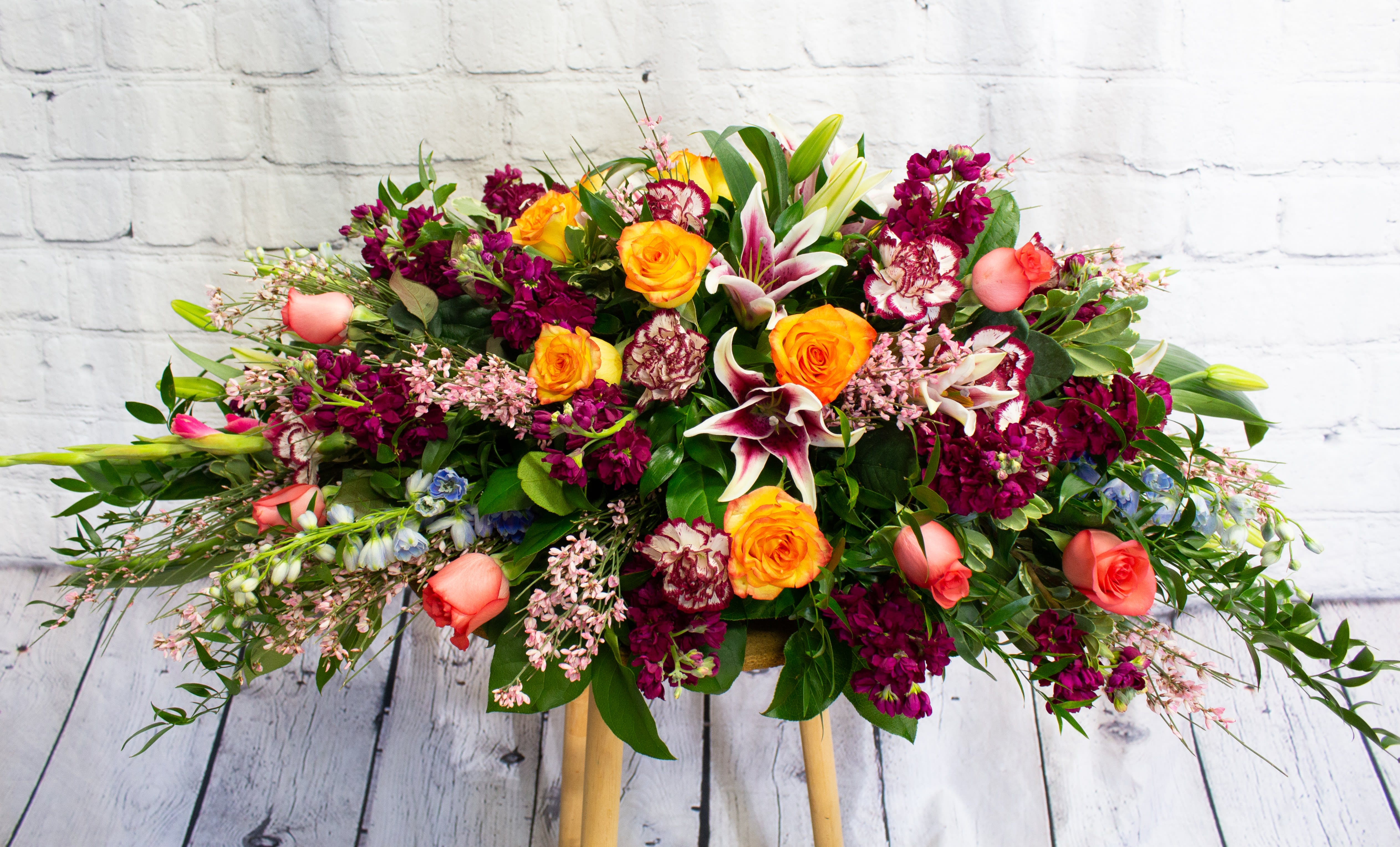Large mixed bouquet with orange roses, lilies, and magenta flowers