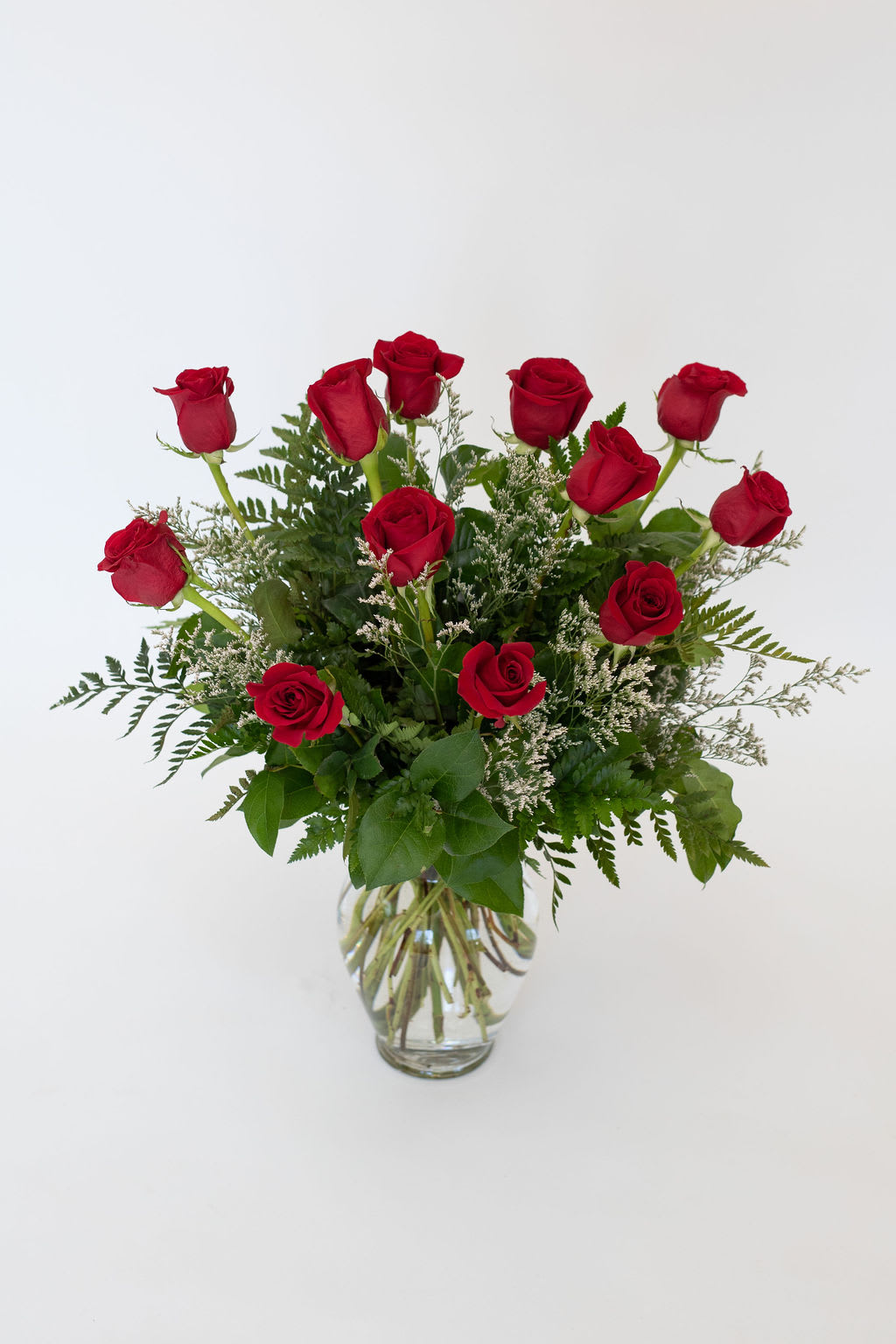 Red roses arranged in a clear glass vase