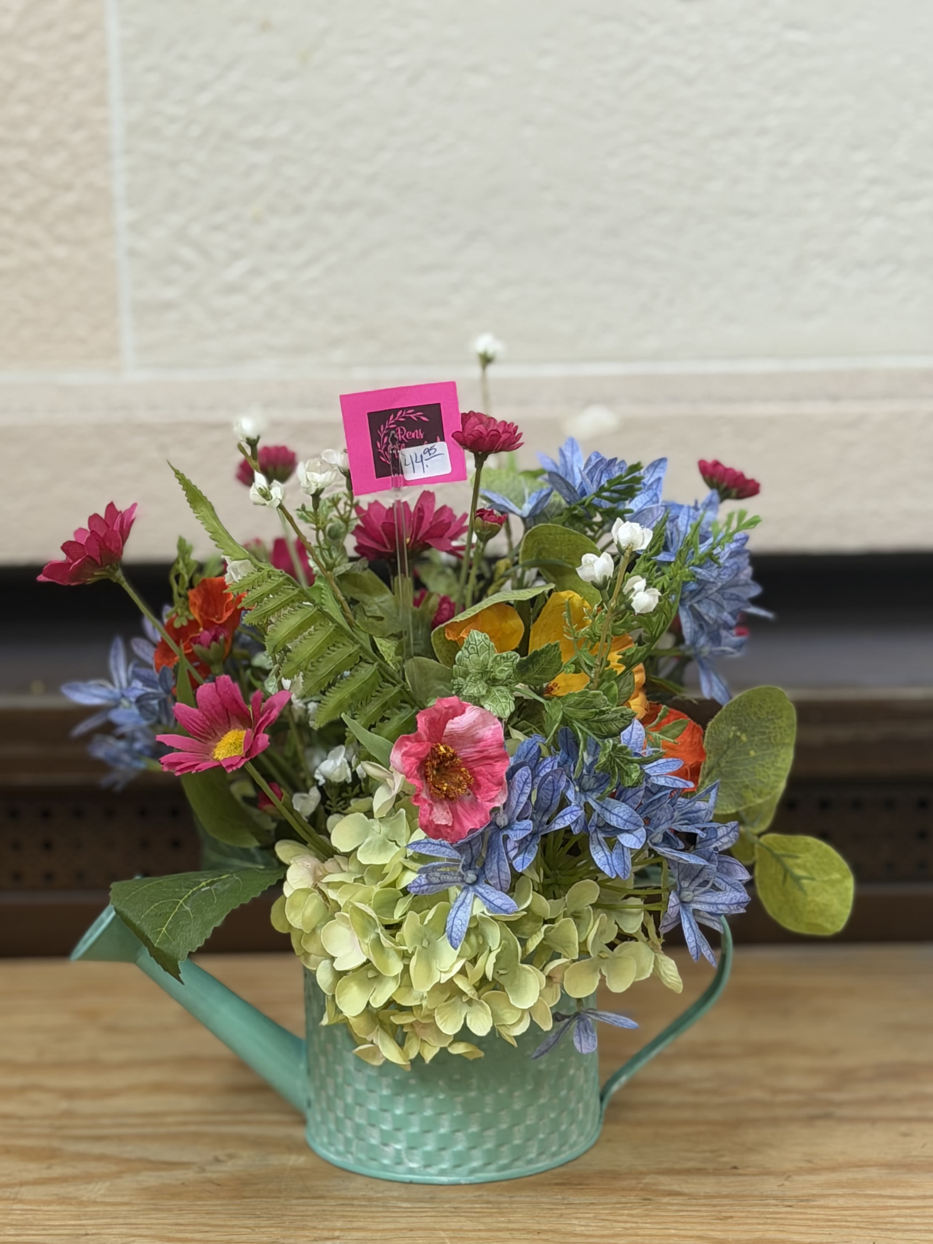 Artificial Watering Can  - A colorful artificial arrangement in a watering can container. 