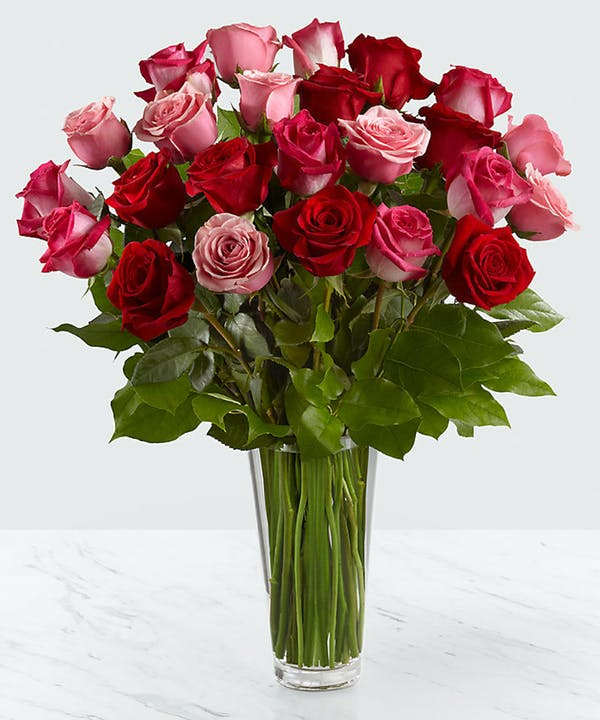 Bouquet of red and pink roses in a clear glass vase