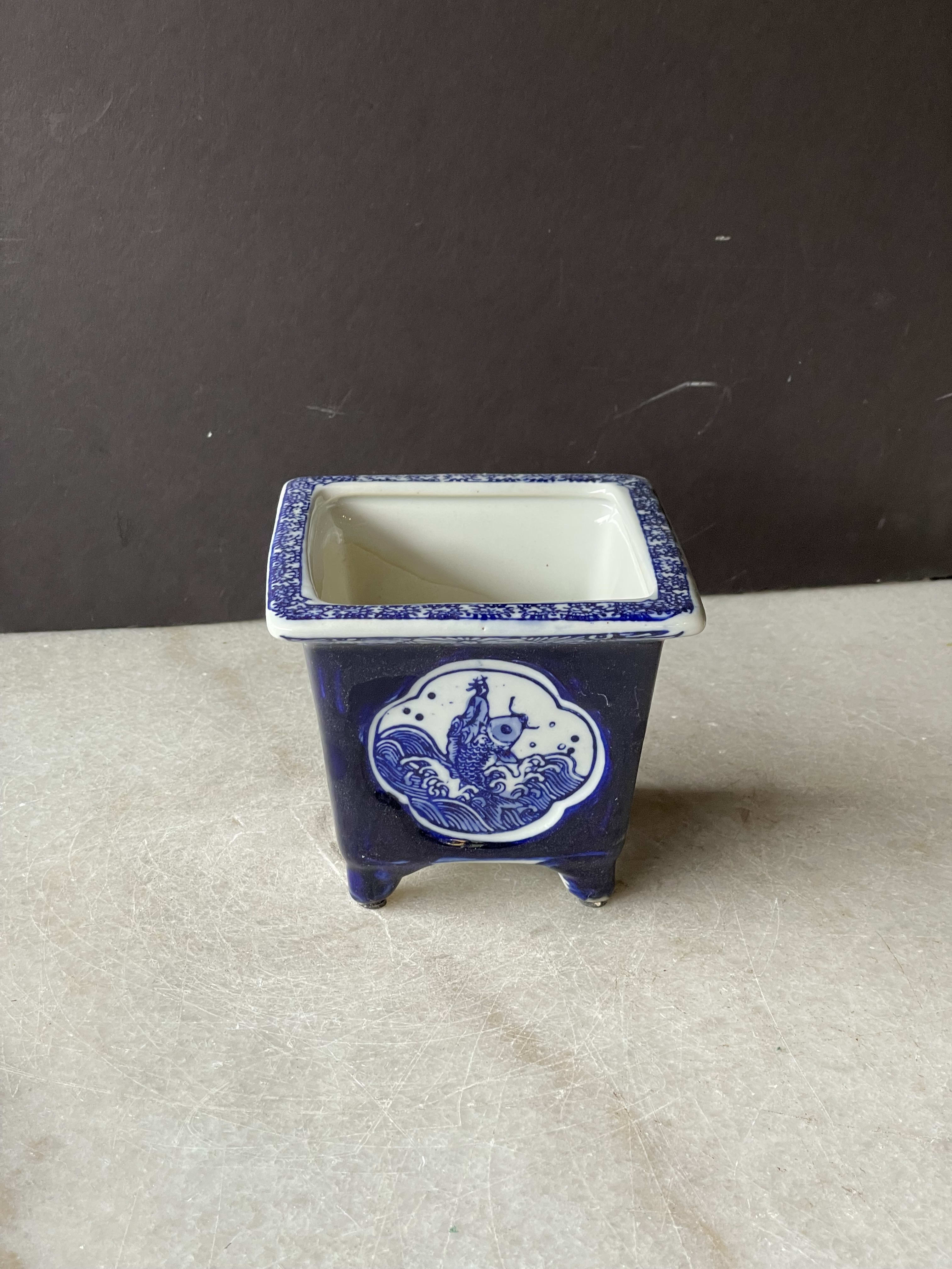 Blue-and-white ceramic square planter with a fish design