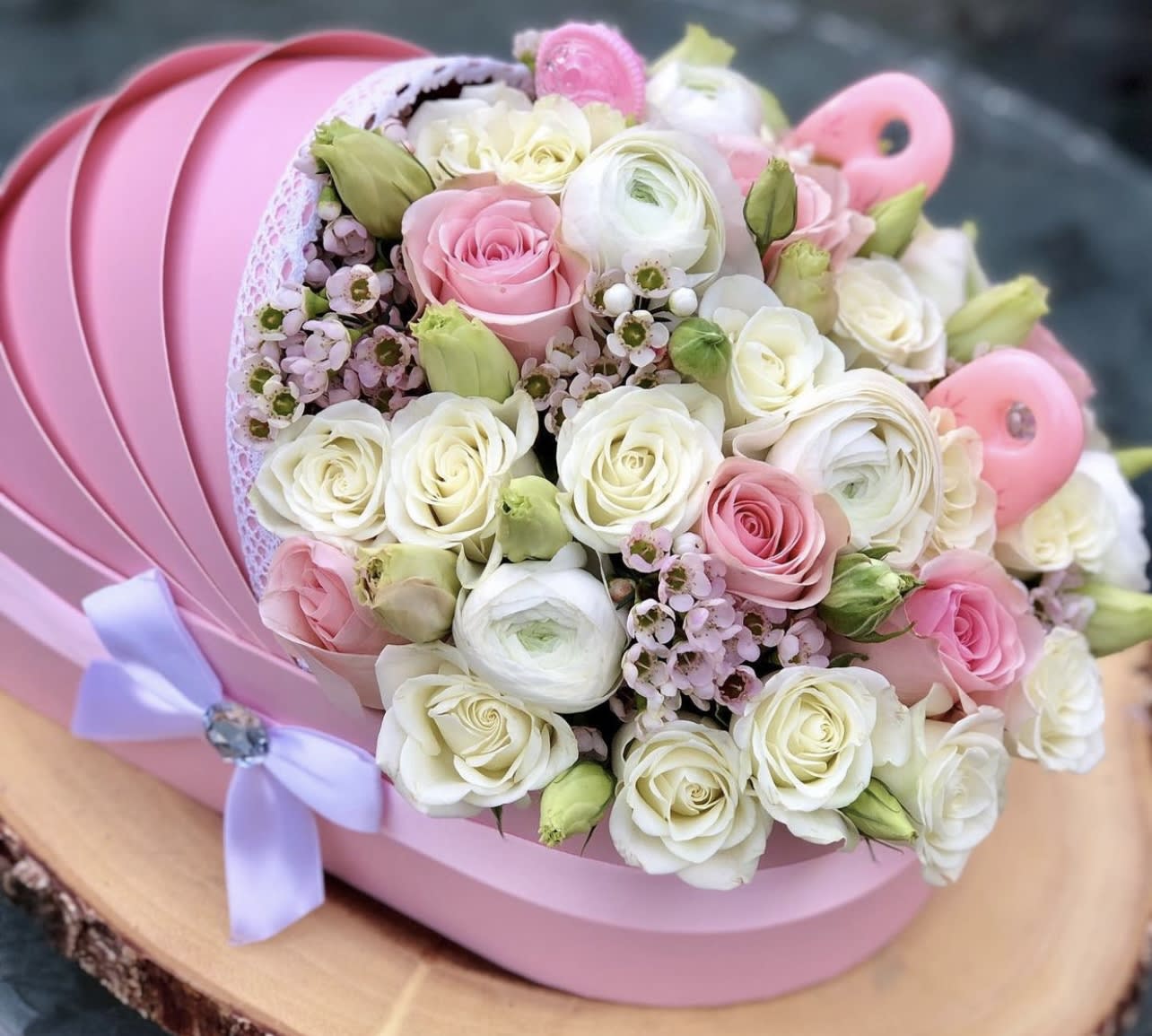 Pink and white rose bouquet in a pink hat box with a lavender ribbon