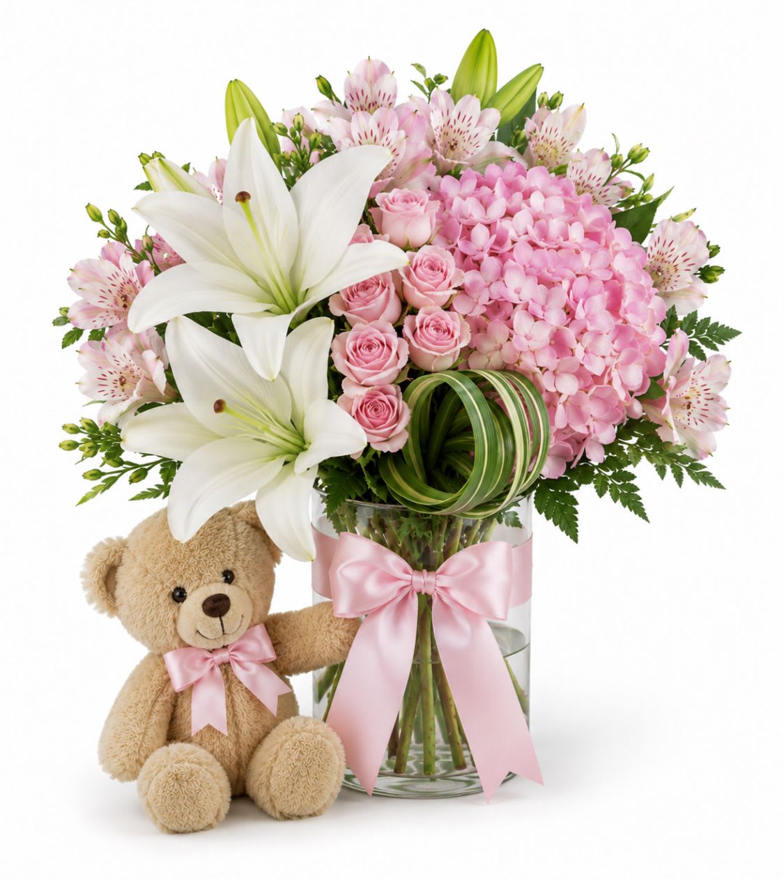  Big. Hud - Soft, tender pastels make an immediate, heartwarming impression - perfect as a new baby gift or a gentle get-well surprise. This baby girl flower arrangement blends lilies, pale pink roses, alstroemeria and carnations with rounded pink hydrangea and creamy filler blooms to create a layered, comforting look that reads as both affectionate and graceful. The inclusion of white lilies lifts the palette and adds a bright, hopeful note that suits welcoming a newborn or offering sympathy during difficult times.  Arranged in your choice of a matte pink vase or a clear glass vase finished with a wide pink satin ribbon, the bouquet comes with a small teddy bear tucked at the base for an extra hug-like touch. Textures range from the soft ruffle of carnations and hydrangea to the silky petals of roses and the elegant, trumpet-shaped lilies; colors are shades of pink, peach, white, yellow accents, and fresh green foliage for balance. Size and stem counts follow standard florist proportions to create a full, rounded silhouette that sits beautifully on a bedside table or memorial display.  Thoughtful for new parents, comforting for someone recovering, and understated enough for sympathy or funeral settings, this arrangement sends a message of care and gentle support. To keep blooms looking their best, change the water daily and trim stems every few days; if you'd like help with delivery timing for a hospital or service, let us know and we'll coordinate.