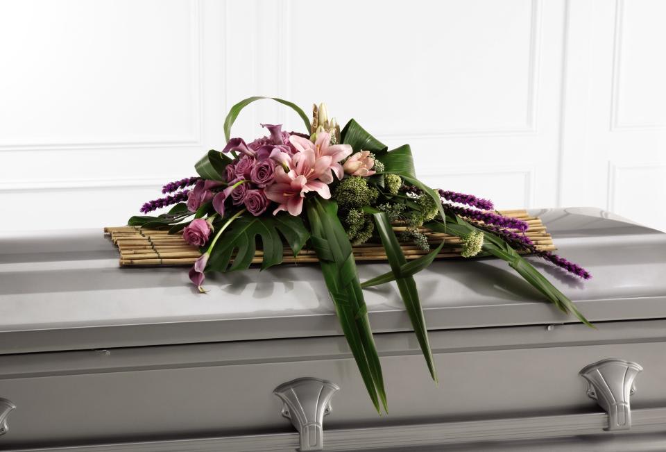 FTD Affection Casket Spray - The FTD Affection Casket Spray exudes sophistication and elegance   for their final farewell service. Lavender roses, purple liatris,   lavender mini calla lilies, white trachelium and pink Asiatic lilies are   offset by a variety of tropical leaves and artfully arranged atop a row   of rivercane stems to create a stunning arrangement meant to bedeck the   top of their casket. A beautiful way to say goodbye.    12h x 36w