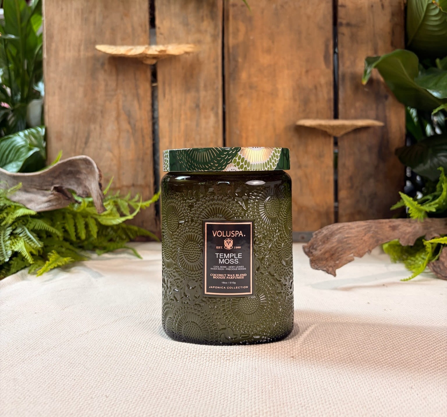 Temple Moss 18 oz Glass Jar Candle - 18 oz glass Voluspa jar candle in the scent Temple Moss.  Fragrance Notes: Cool moss, dewy leaves, wet stones and warm sun peeking through a thicket of Hinoki branches.