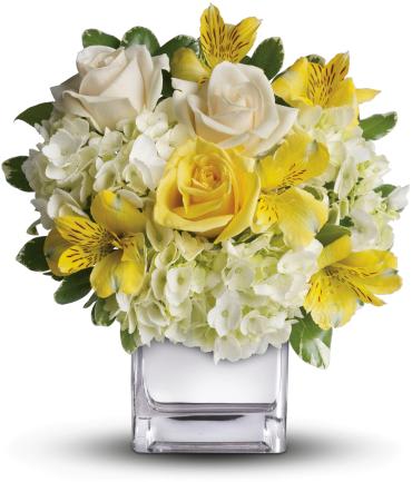 Yellow and white bouquet in a clear square vase