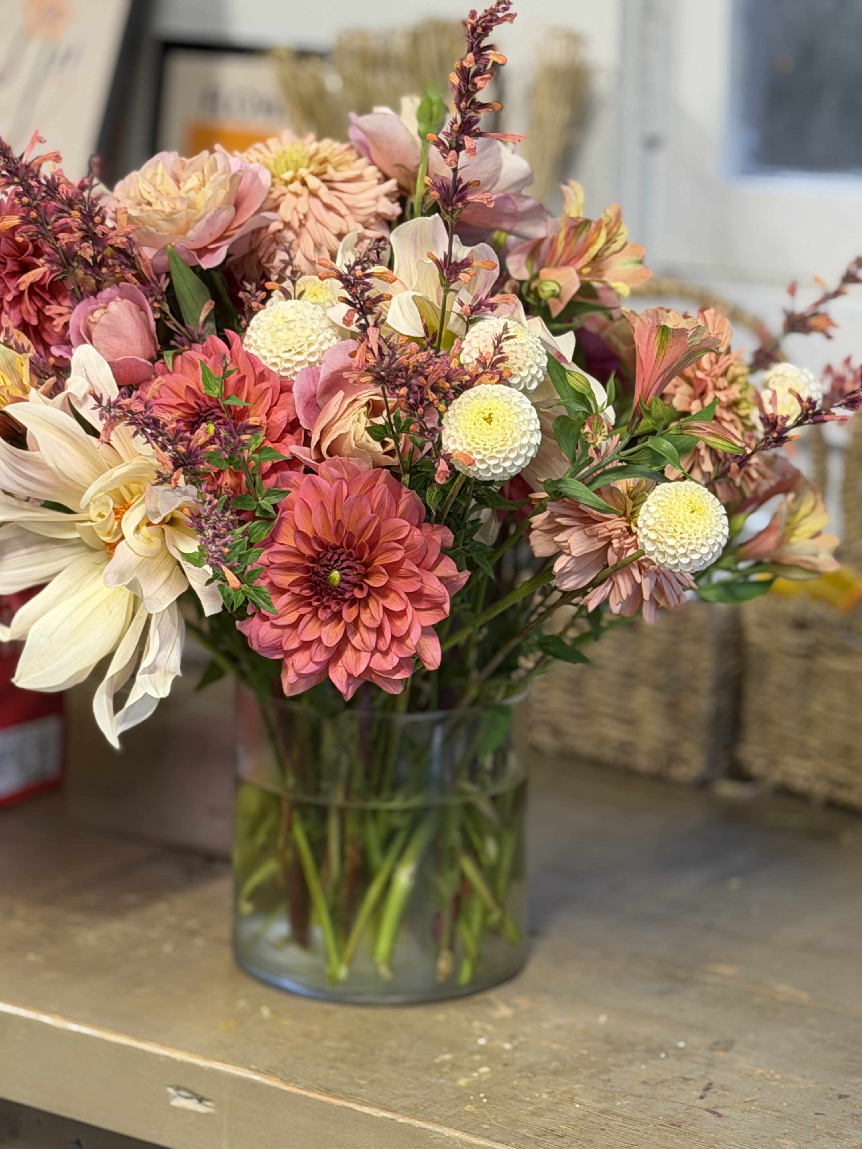 Mixed pink and cream flowers arranged in a clear glass vase