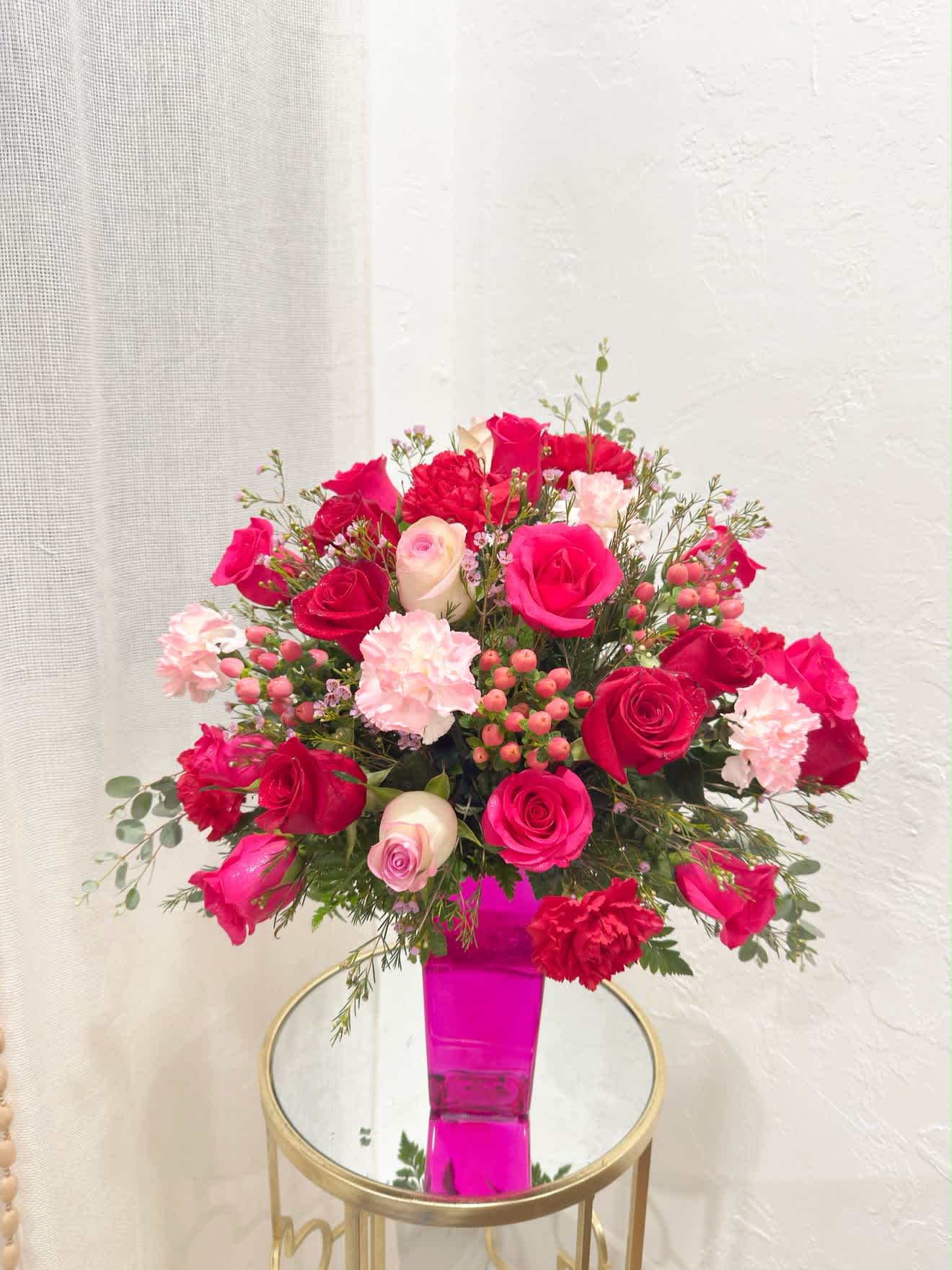 Pink and red rose bouquet in a bright pink vase