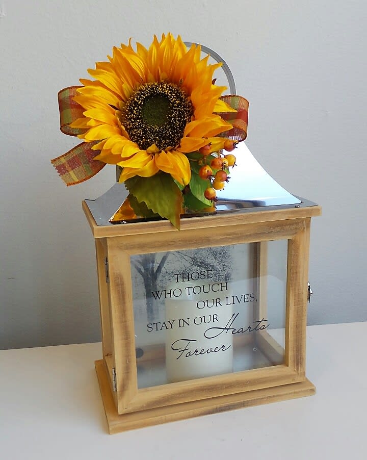 Sunflower arrangement on a wooden memorial lantern with a candle inside