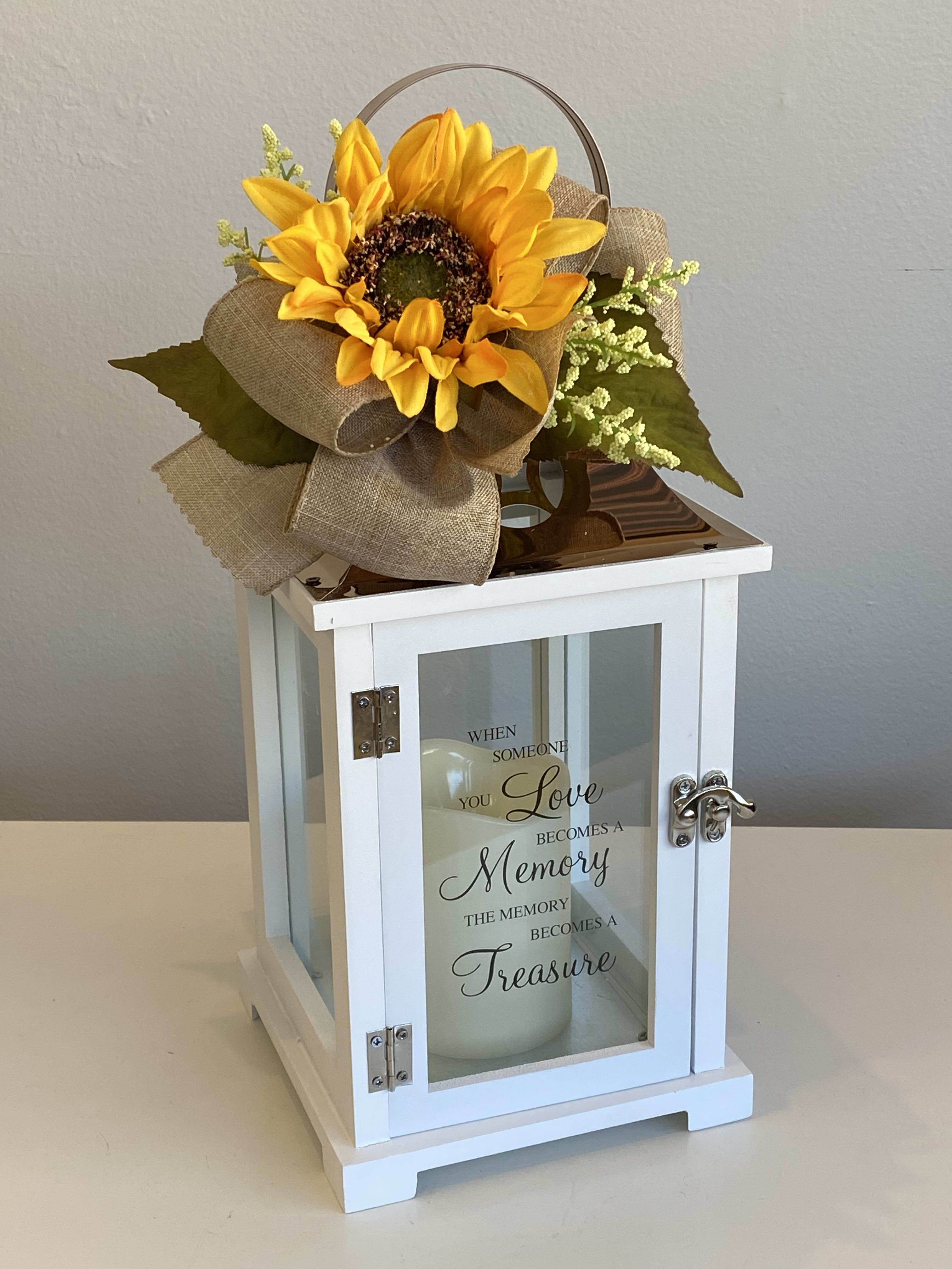 Sunflower arrangement on a white lantern with a memorial quote