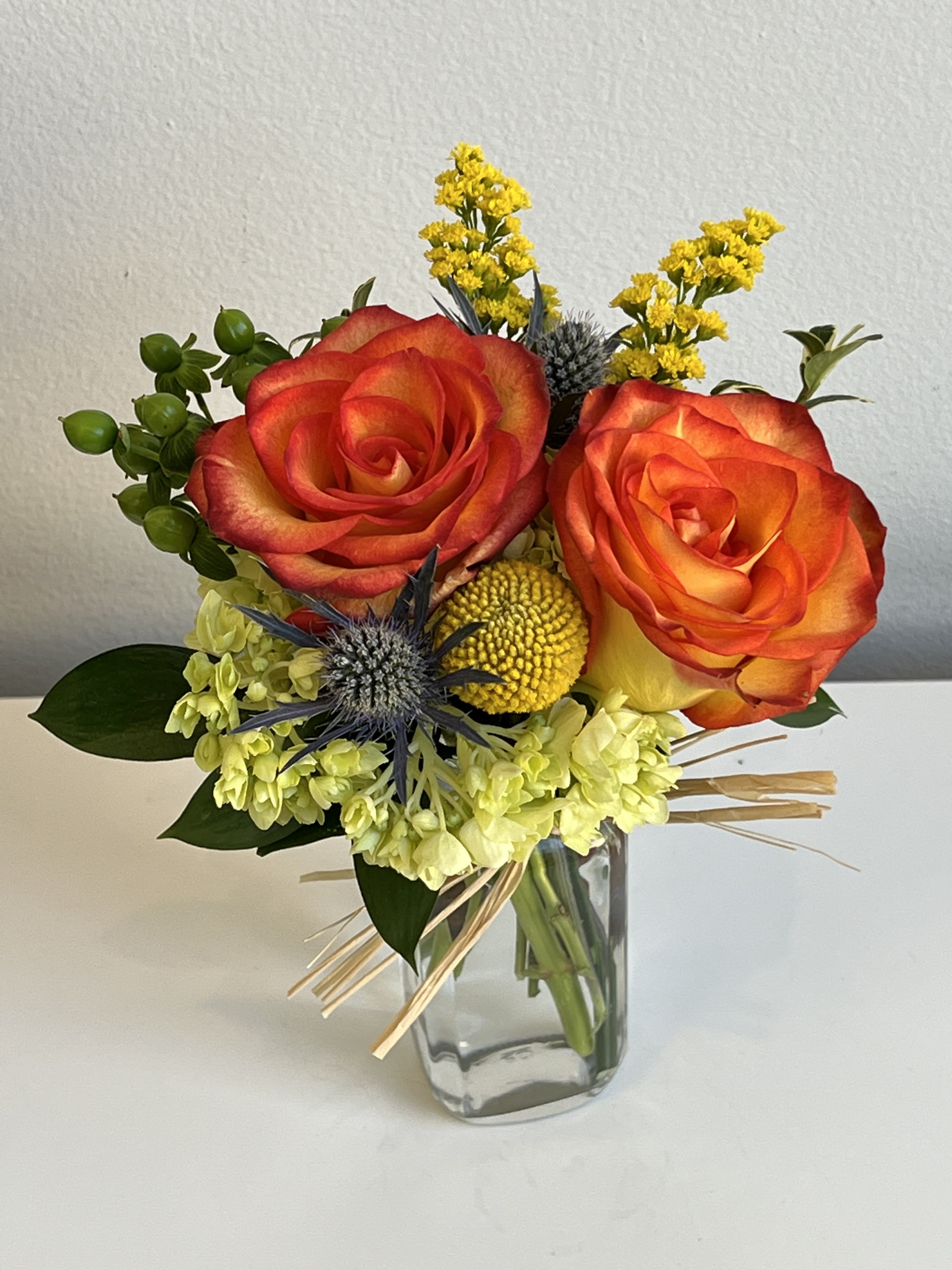 Bouquet of orange-red roses in a clear glass vase