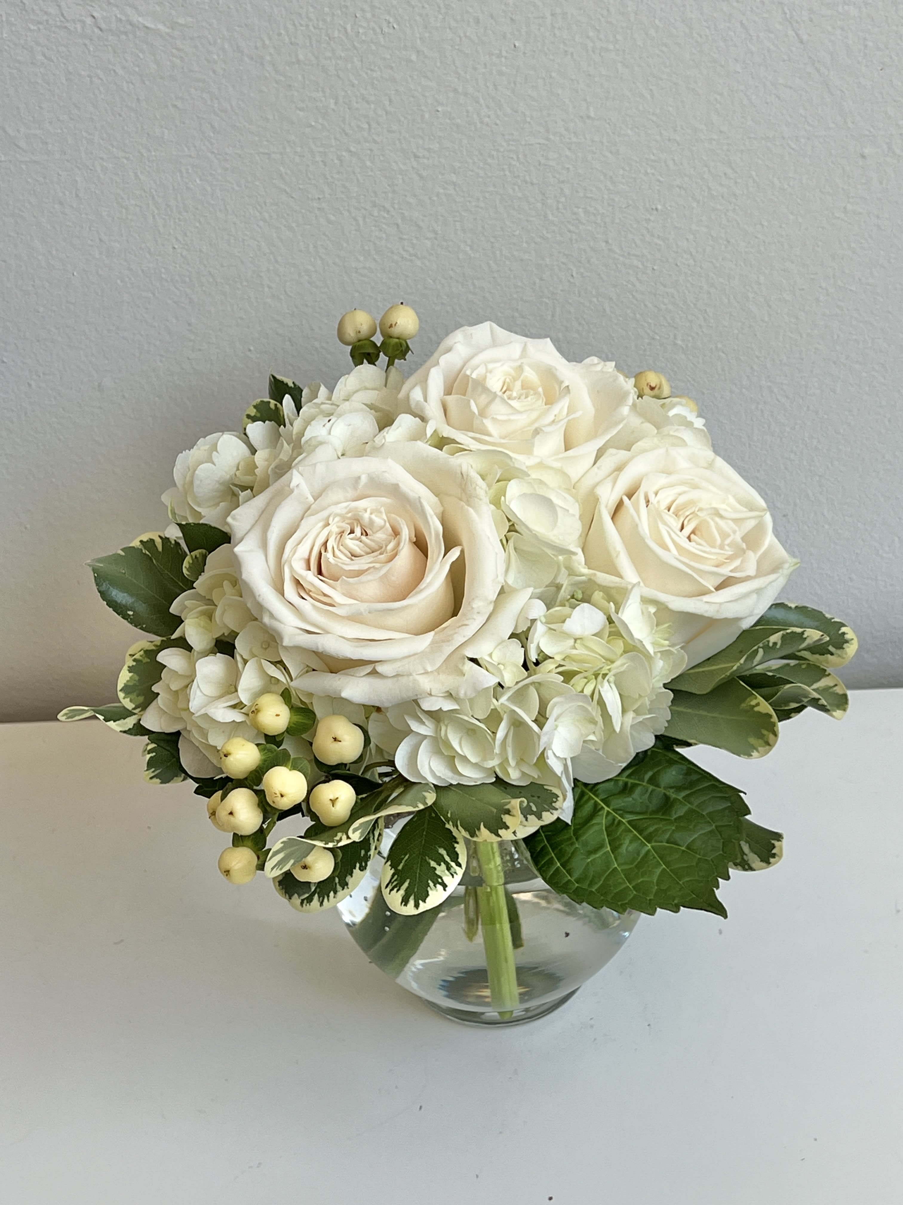 White rose and hydrangea bouquet in a clear glass vase
