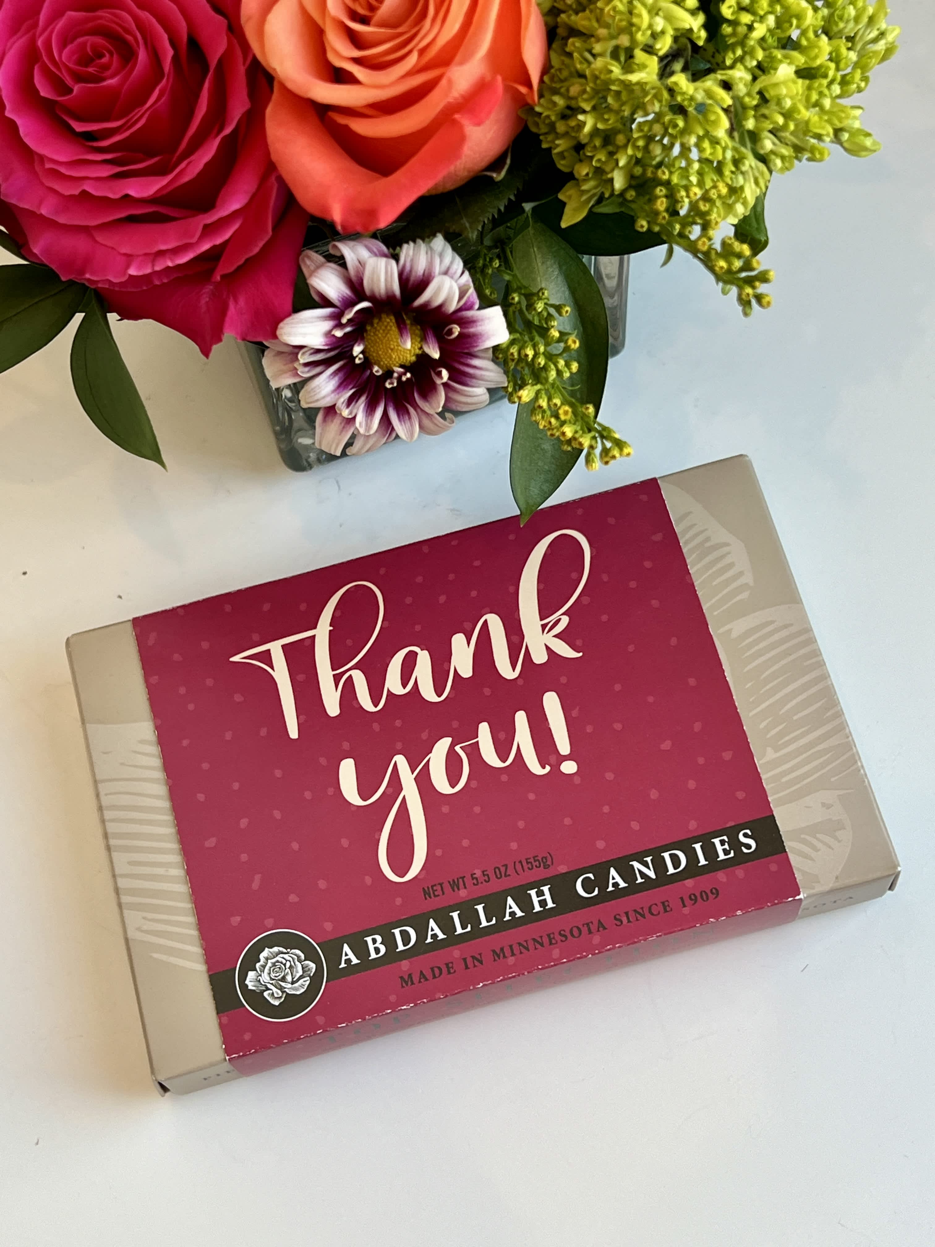 Flowers beside a thank-you candy box