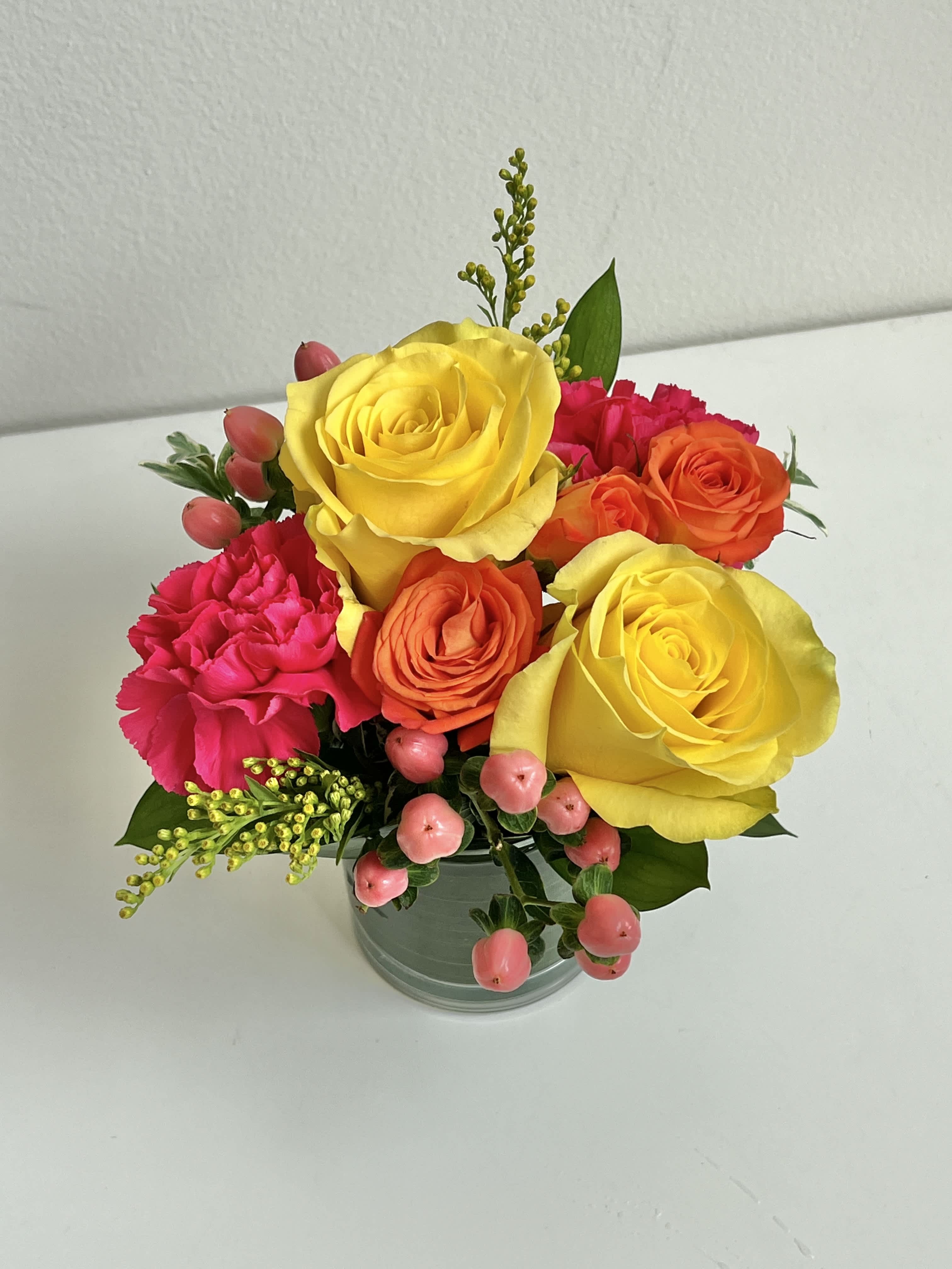 Bouquet of yellow, orange, and pink flowers in a glass vase