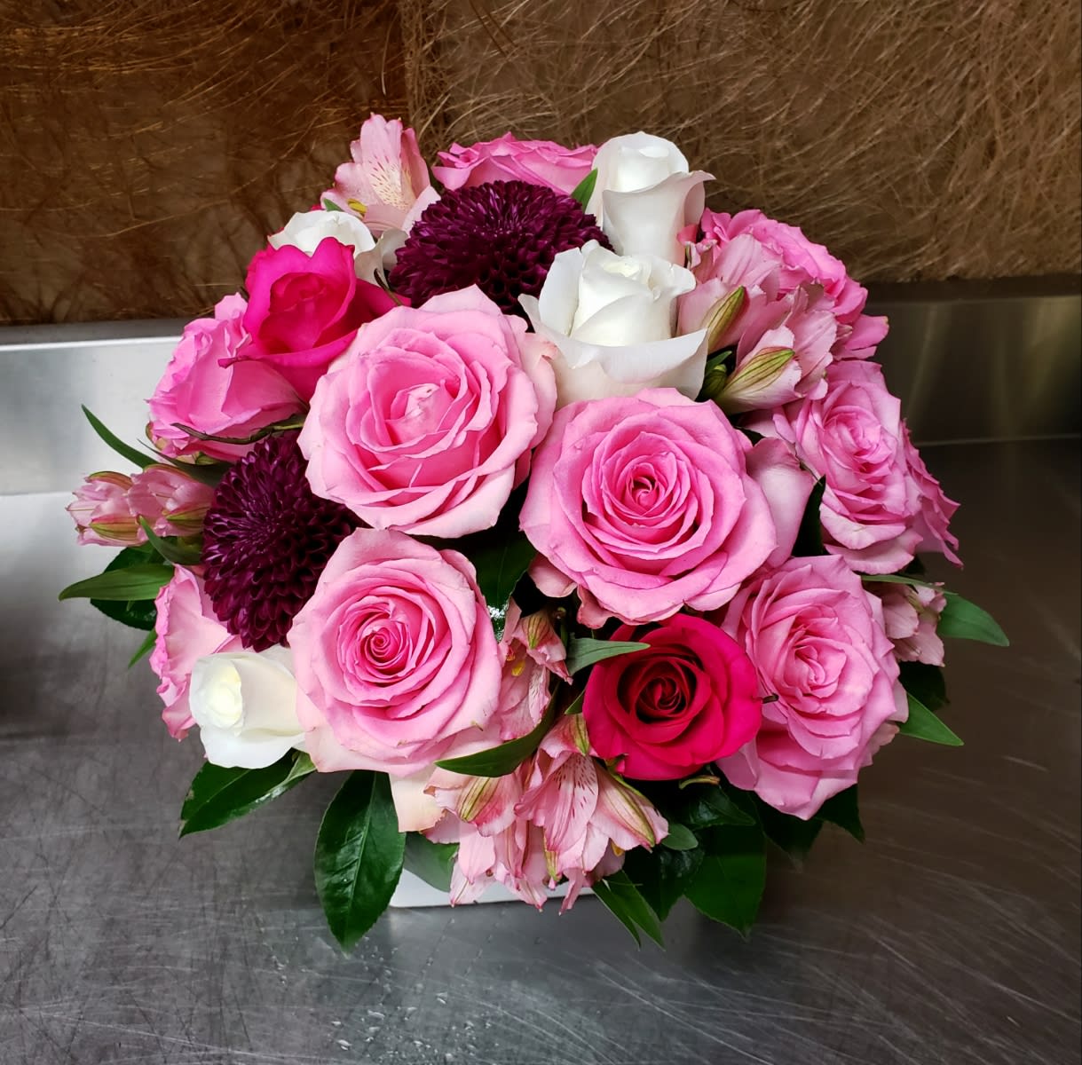 Bouquet of pink and white roses with dark purple blooms