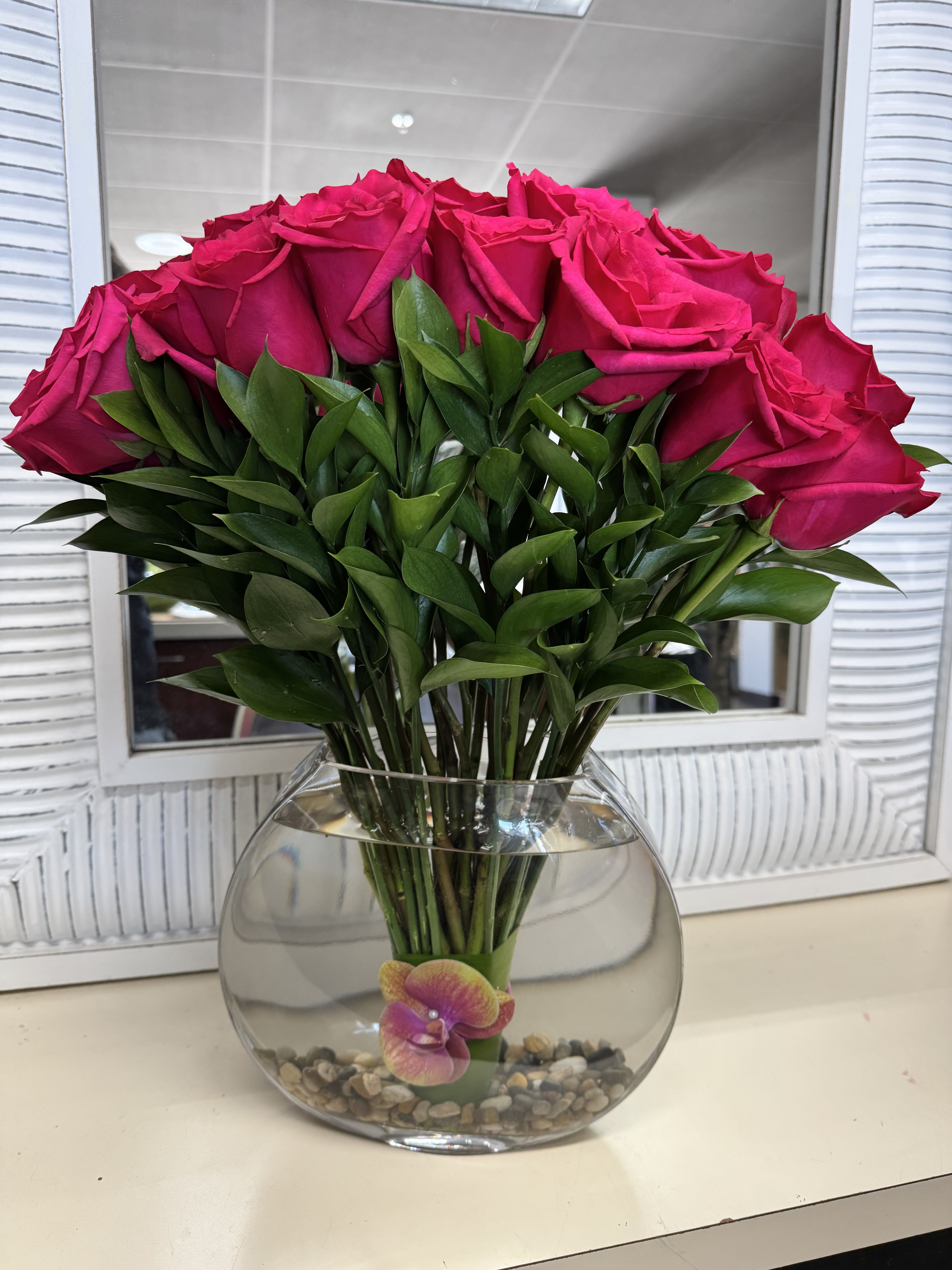 Bouquet of hot pink roses in a round glass vase