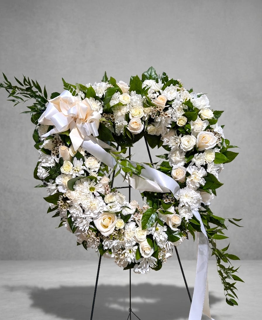 Pure Heart – White Rose Funeral Wreath Sympathy Spray - 18" open heart decorated with white seasonal flowers accent with a bow.