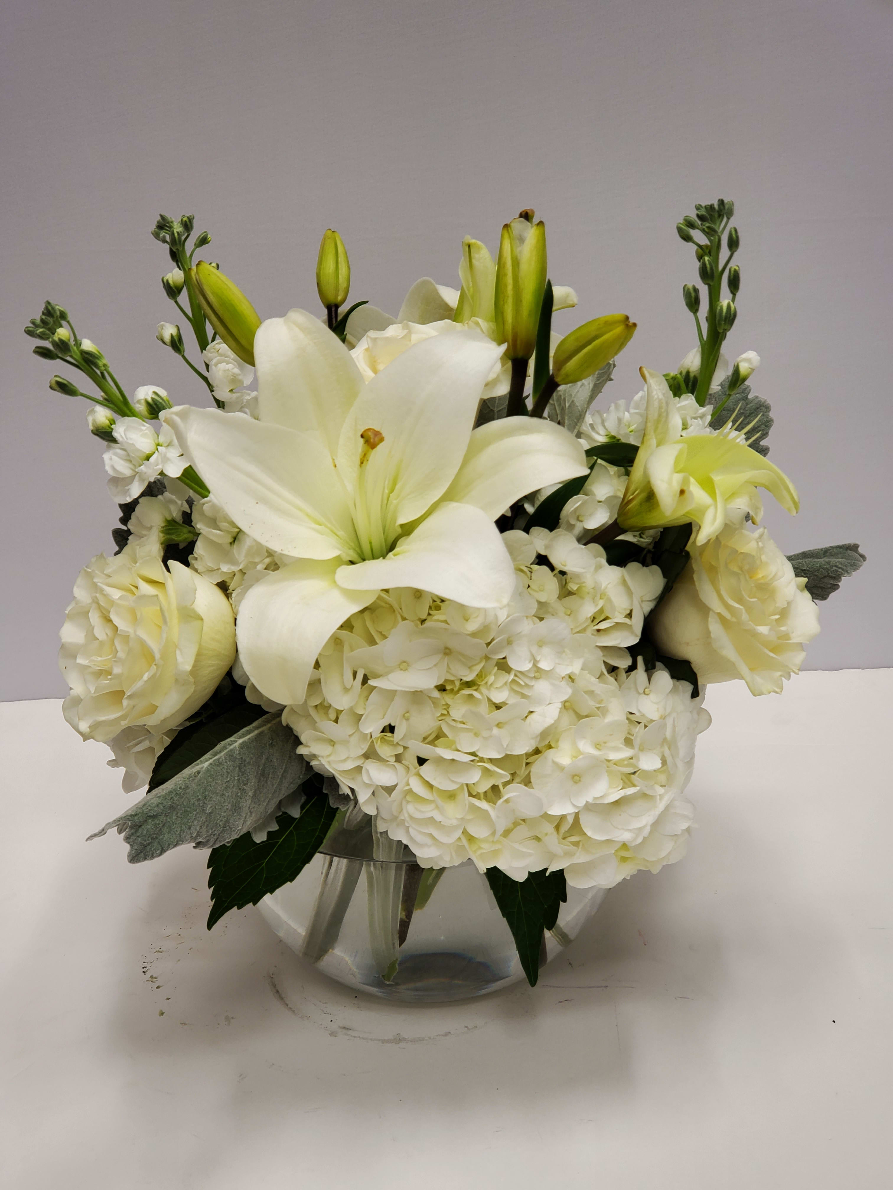 Sweet Thoughts - This arrangement includes white roses, white asiatic lilies, white stock, and dusty miller. Send your condolences with Sweet Thoughts.