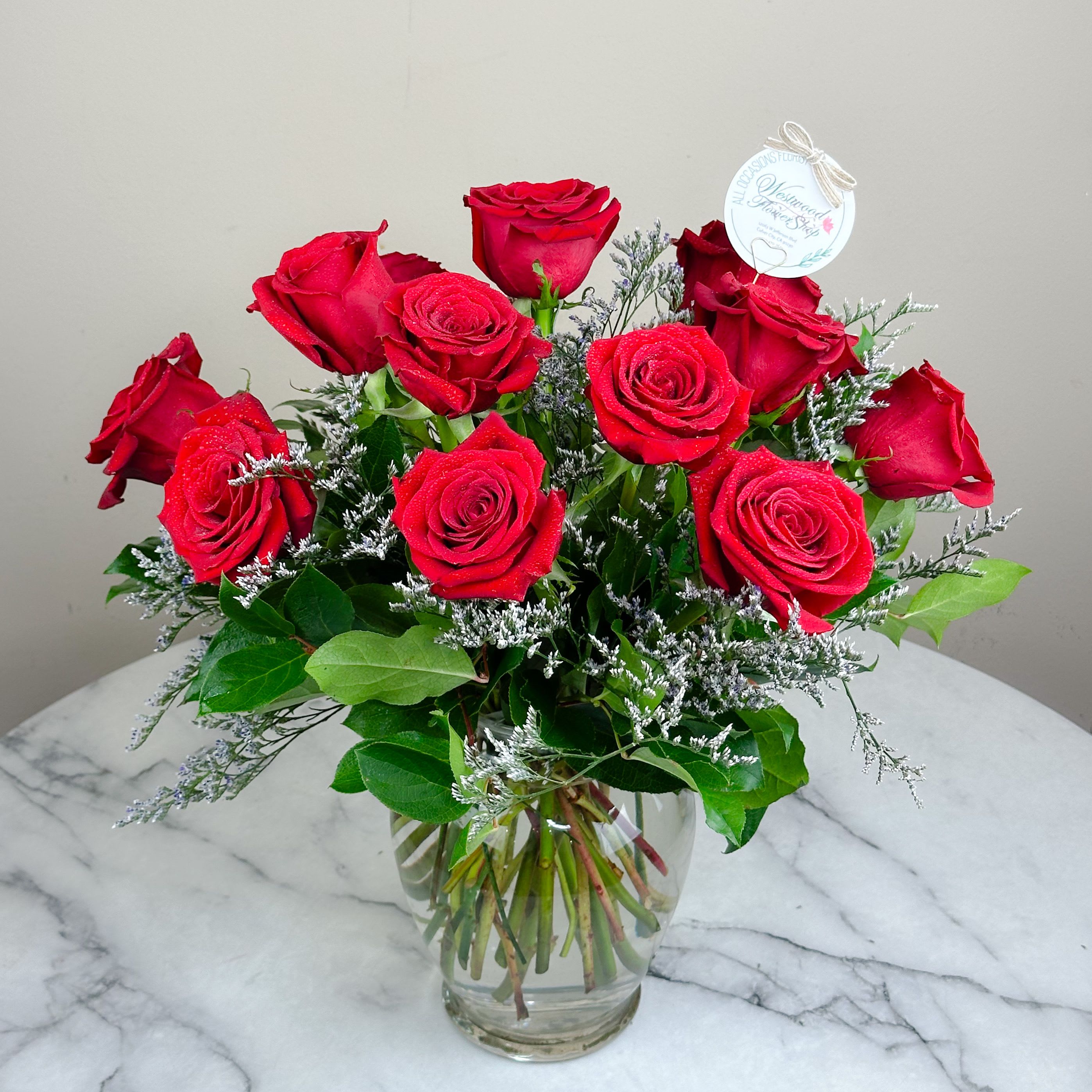 Forever Love Bouquet - A charming bouquet of a dozen long stem red roses to bring the love and romance especially on Valentine's Day! Designed with elegant fillers and greenery in a tall ginger vase, this gift will be in her heart and remembered forever.  *Available in many colors! Please indicate your preference at the "Special Instructions" upon checkout.  Approximately 14" D