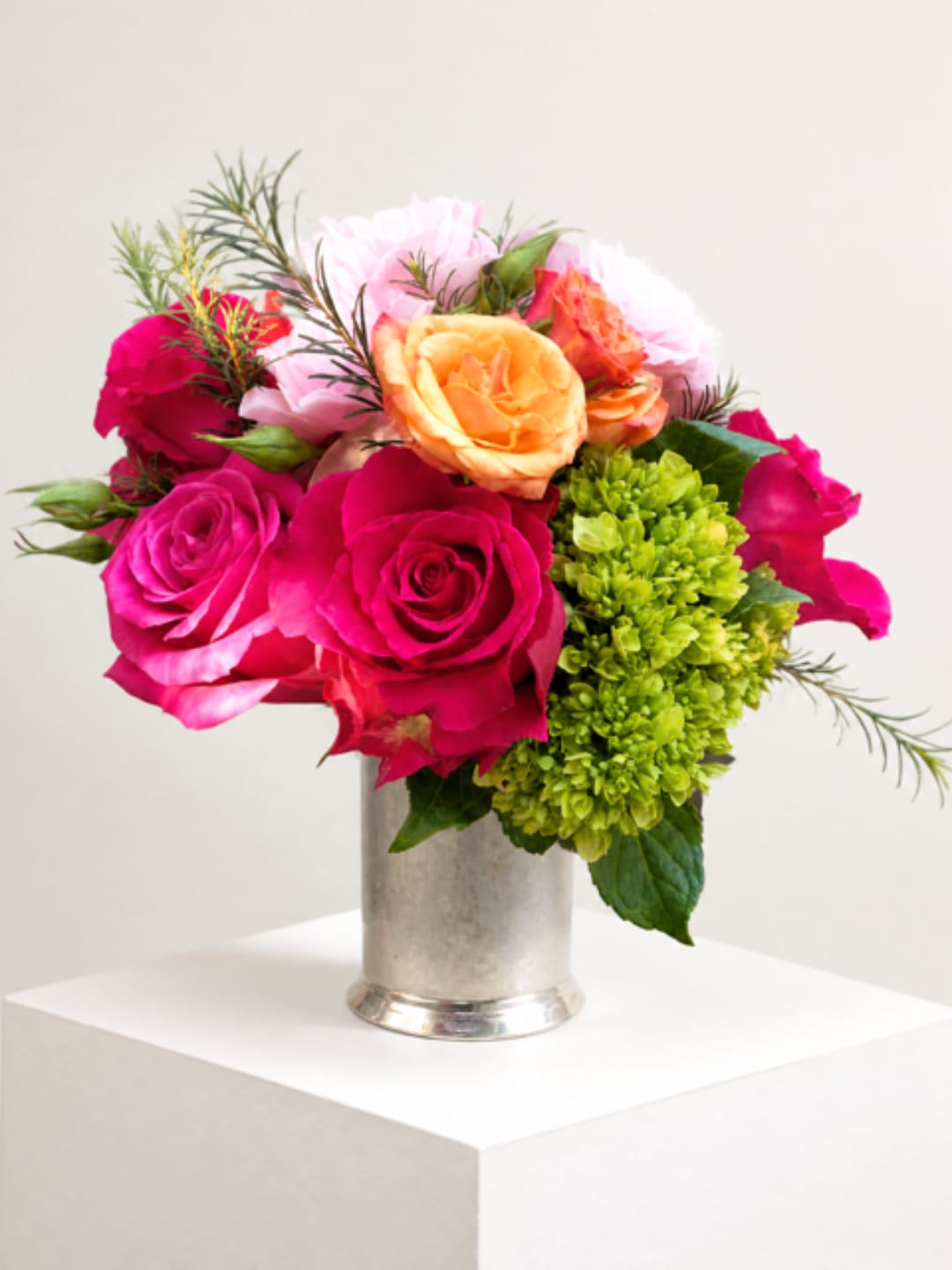 Bright pink and peach roses in a silver vase