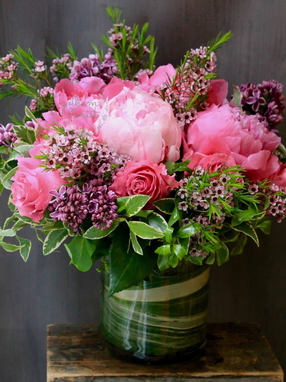 Pink peonies and roses arranged in a glass vase