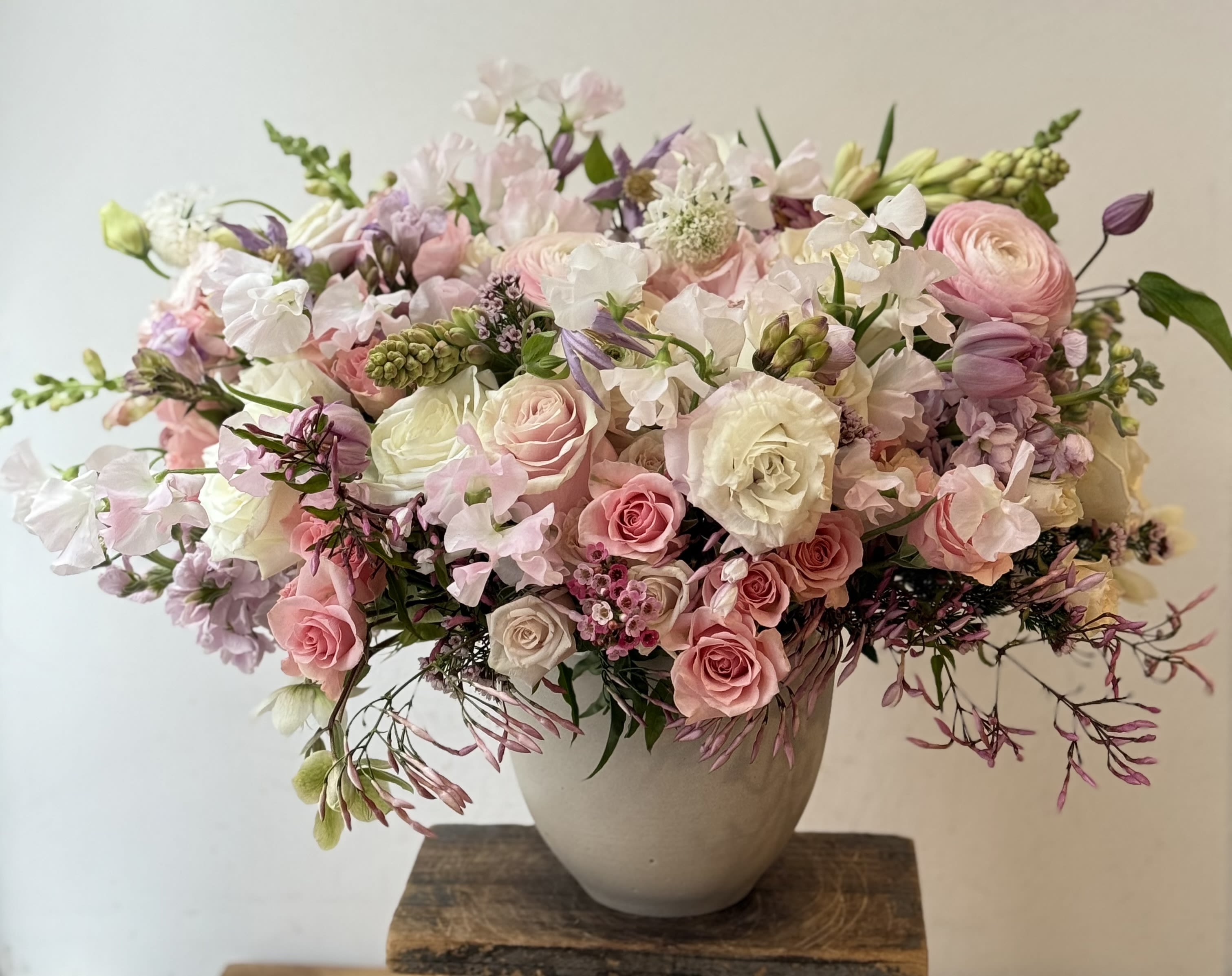 Angel - Discover the epitome of elegance and grace with our enchanting white vase, a masterpiece filled to the brim with a mesmerizing array of lush pink and white blooms. Each vase is a symphony of color, featuring a meticulously curated selection of garden roses, ranunculus, freesia, classic roses, and anemone. These flowers are not merely placed; they are thoughtfully arranged to evoke a sense of serene beauty and sophisticated charm. The pristine white vase enhances the radiance of the blooms within, creating a harmonious blend of color and light that captivates and delights. This exquisite arrangement transcends the ordinary, making it the perfect gift for special occasions or a luxurious centerpiece that will elevate any space with its breathtaking beauty. Let the allure of our pink and white floral arrangement be the expression of your impeccable taste and the embodiment of luxury in bloom from the best florist in new york.