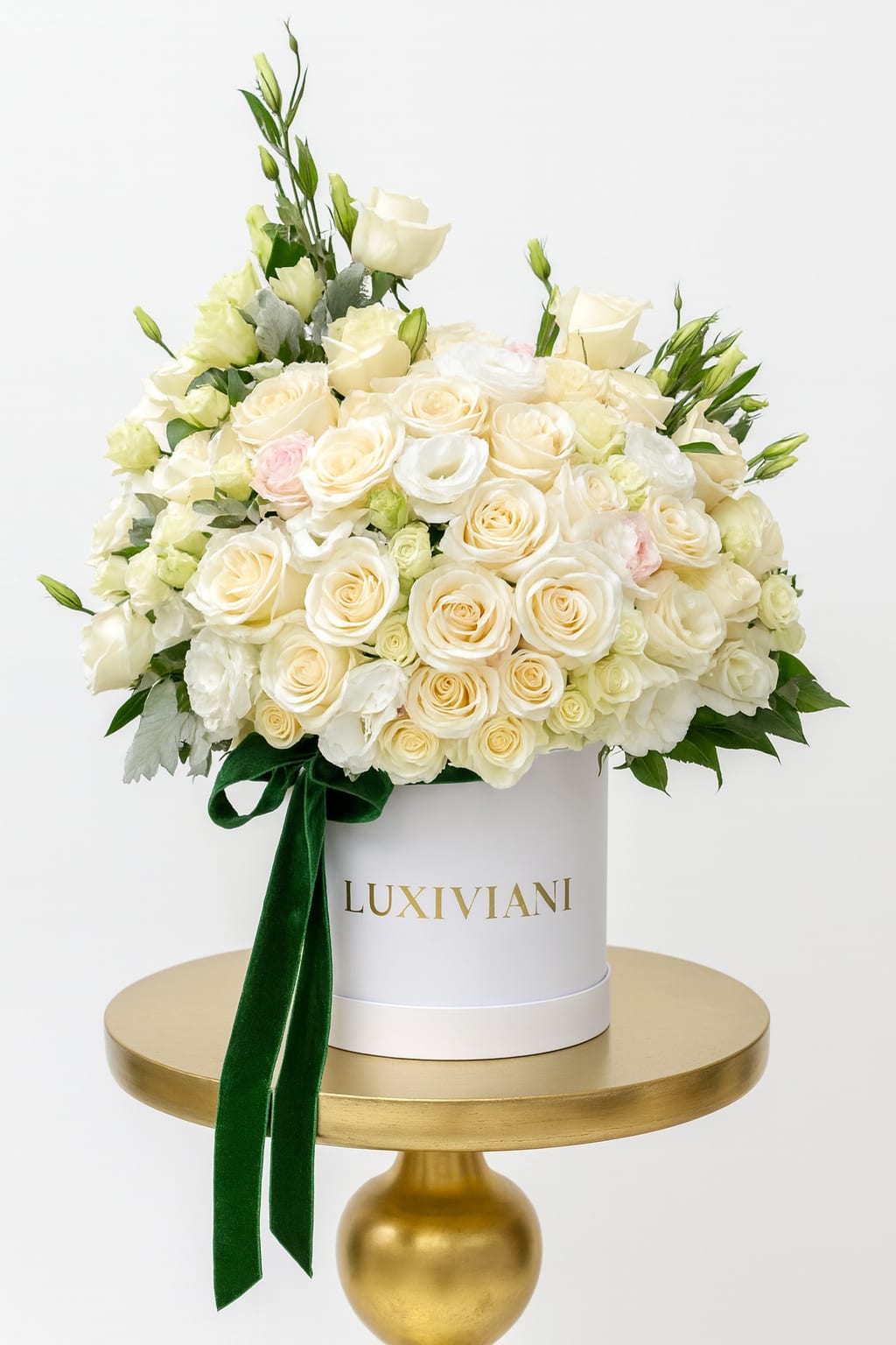 Cream rose arrangement in a white hat box with a green ribbon