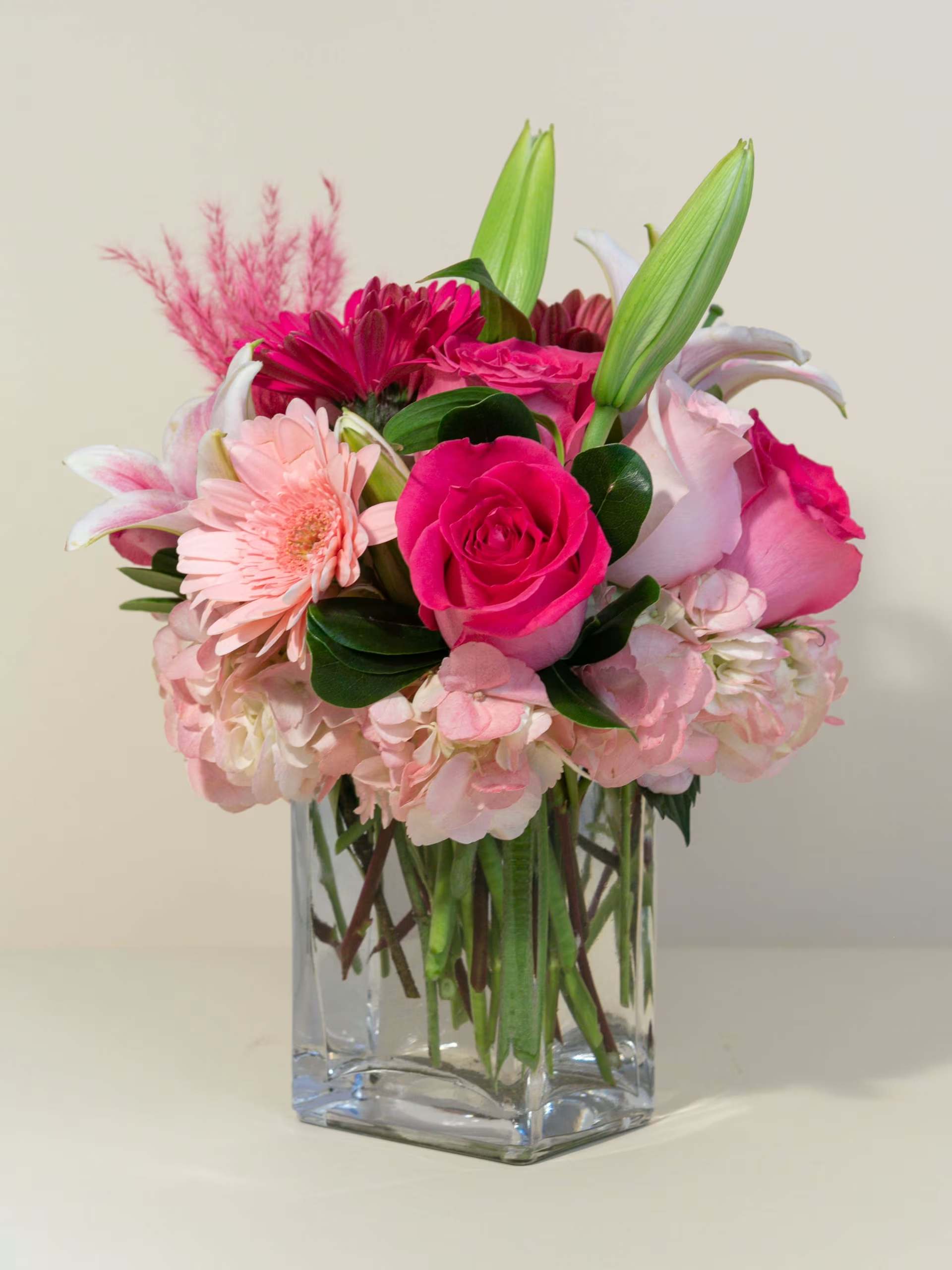 Pink mixed bouquet in a clear square glass vase