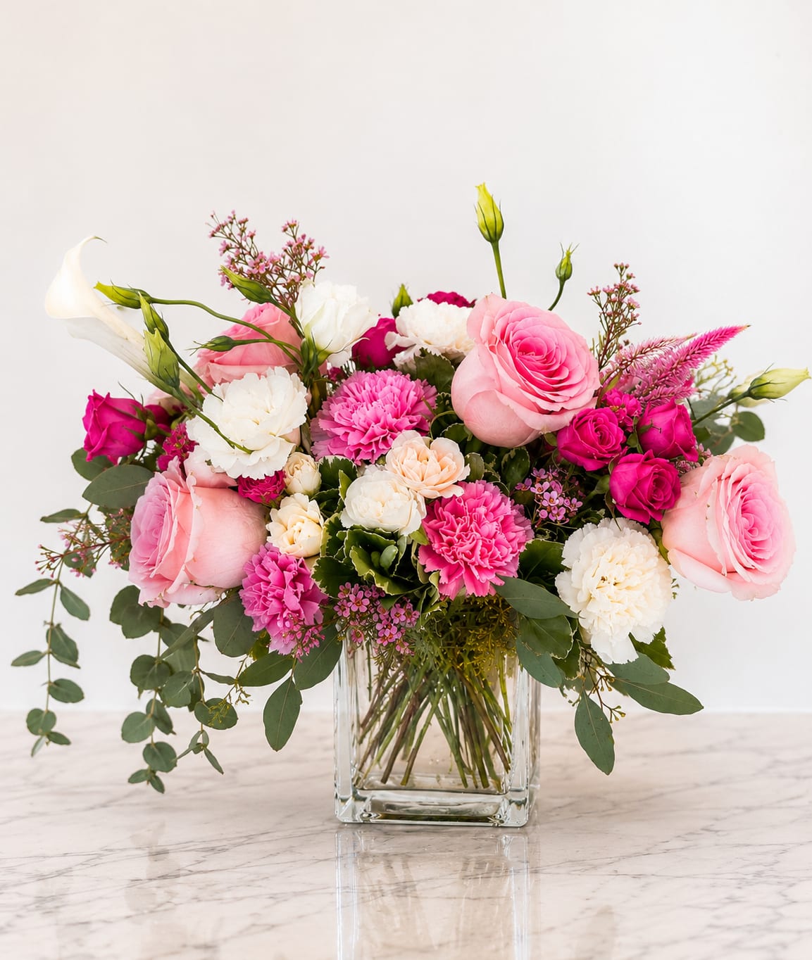Pink and white flower arrangement in a clear glass vase