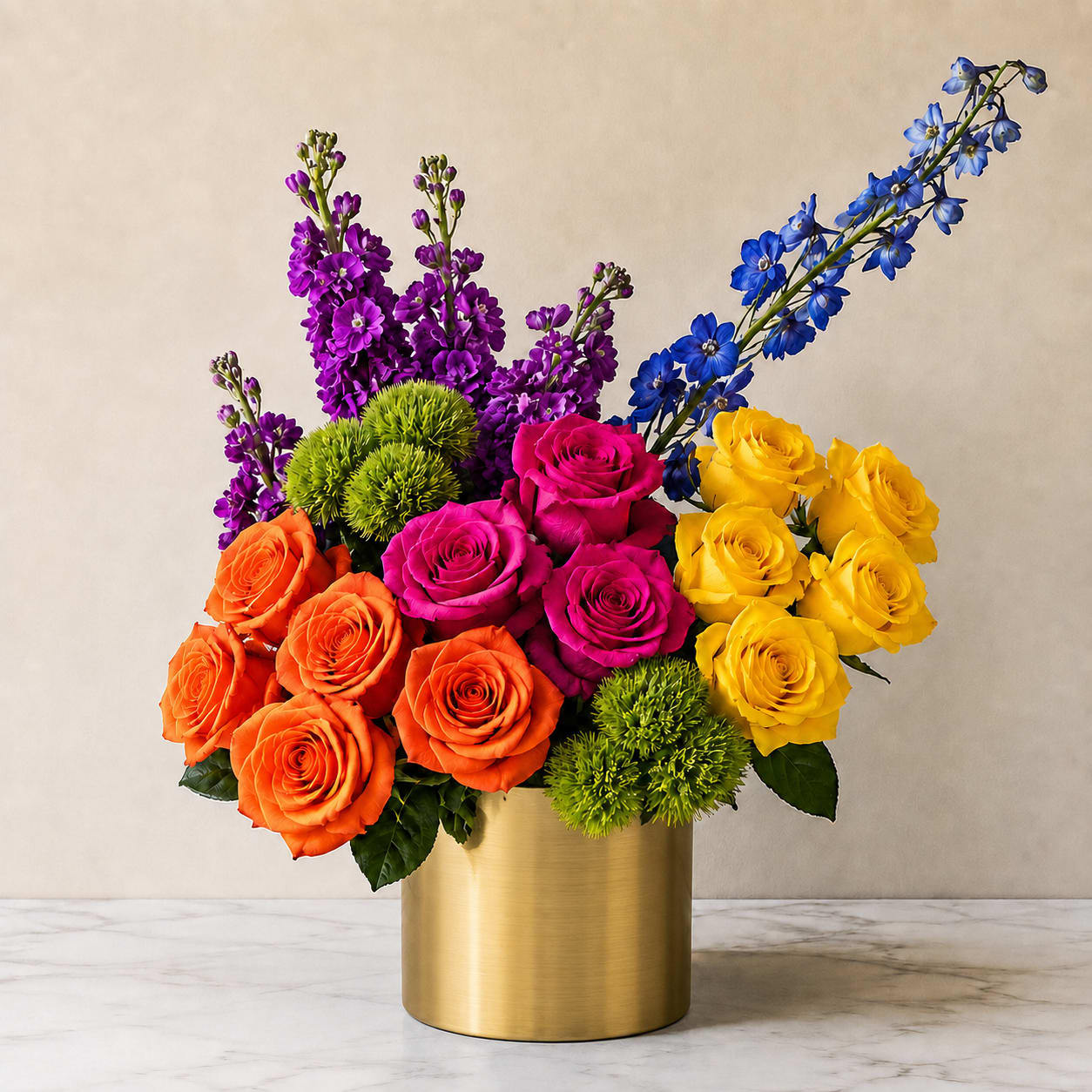 Colorful bouquet of roses and purple-blue flowers in a gold vase