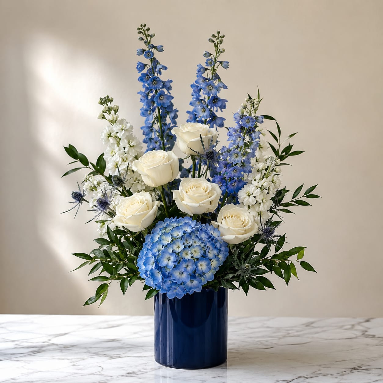 Blue and white floral arrangement in a dark blue vase