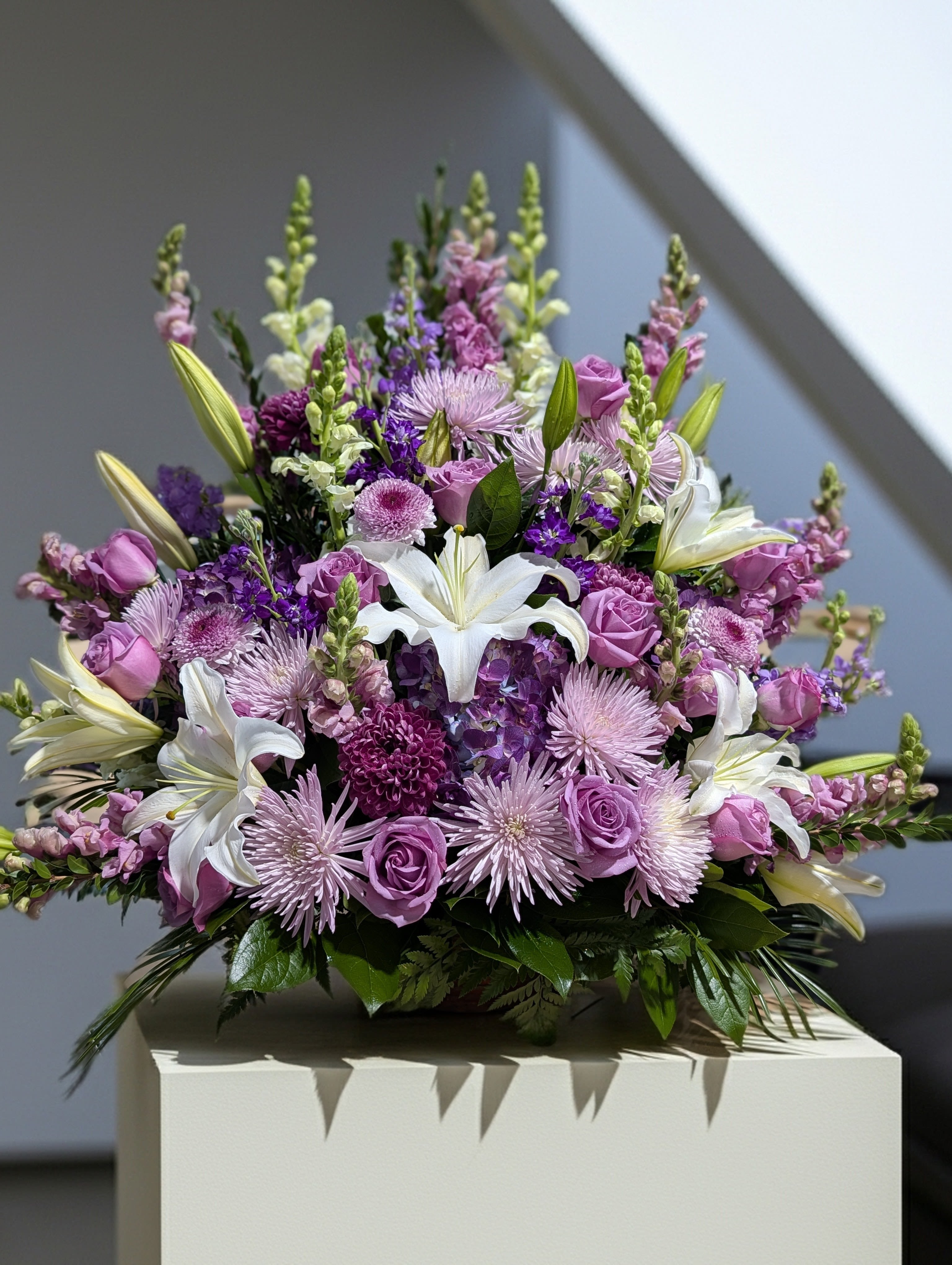 Lavender and white bouquet with lilies and roses in a low arrangement